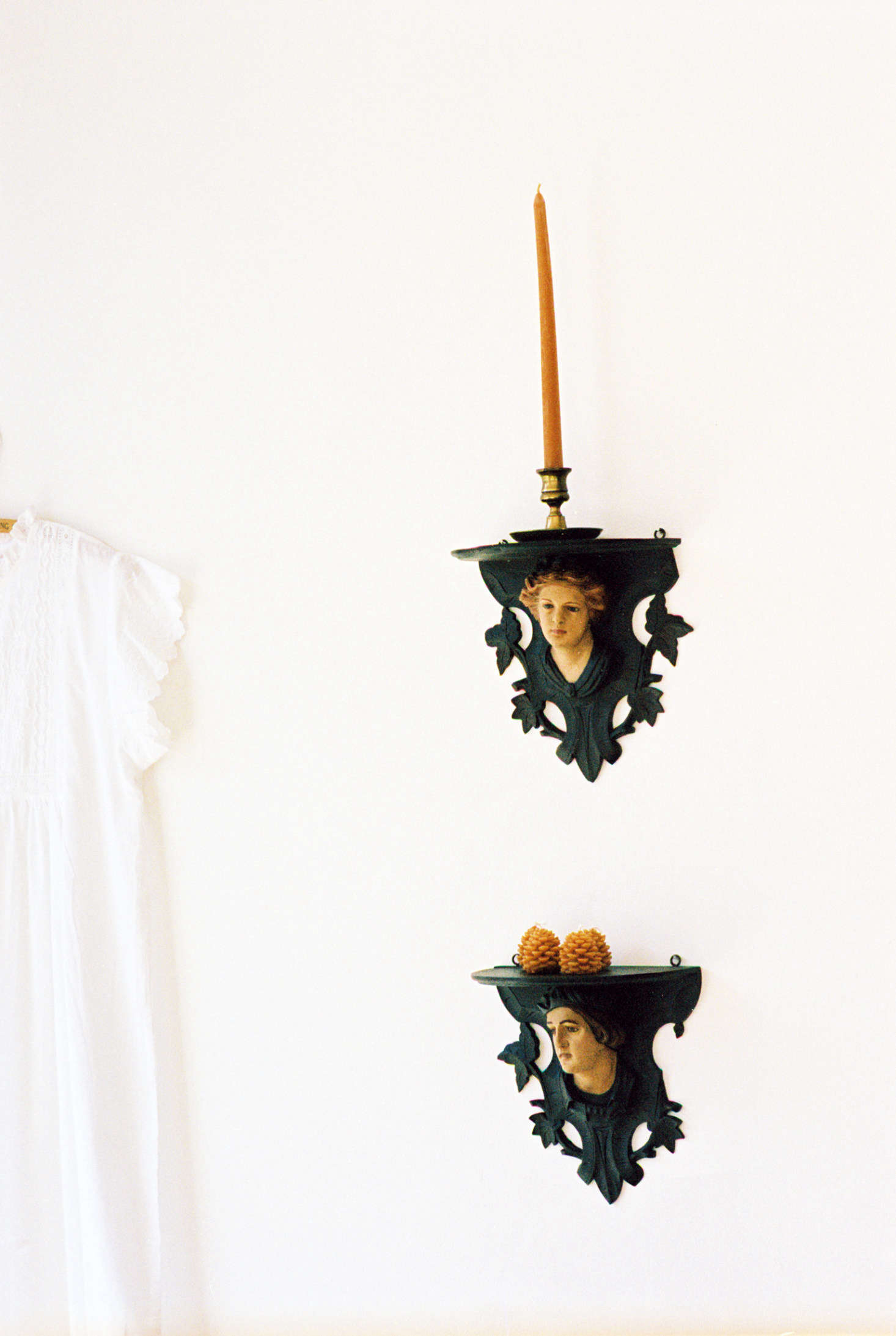 Shelves with a slightly gothic air hold Wee Pine Cone Candles ($24 for a box of four).