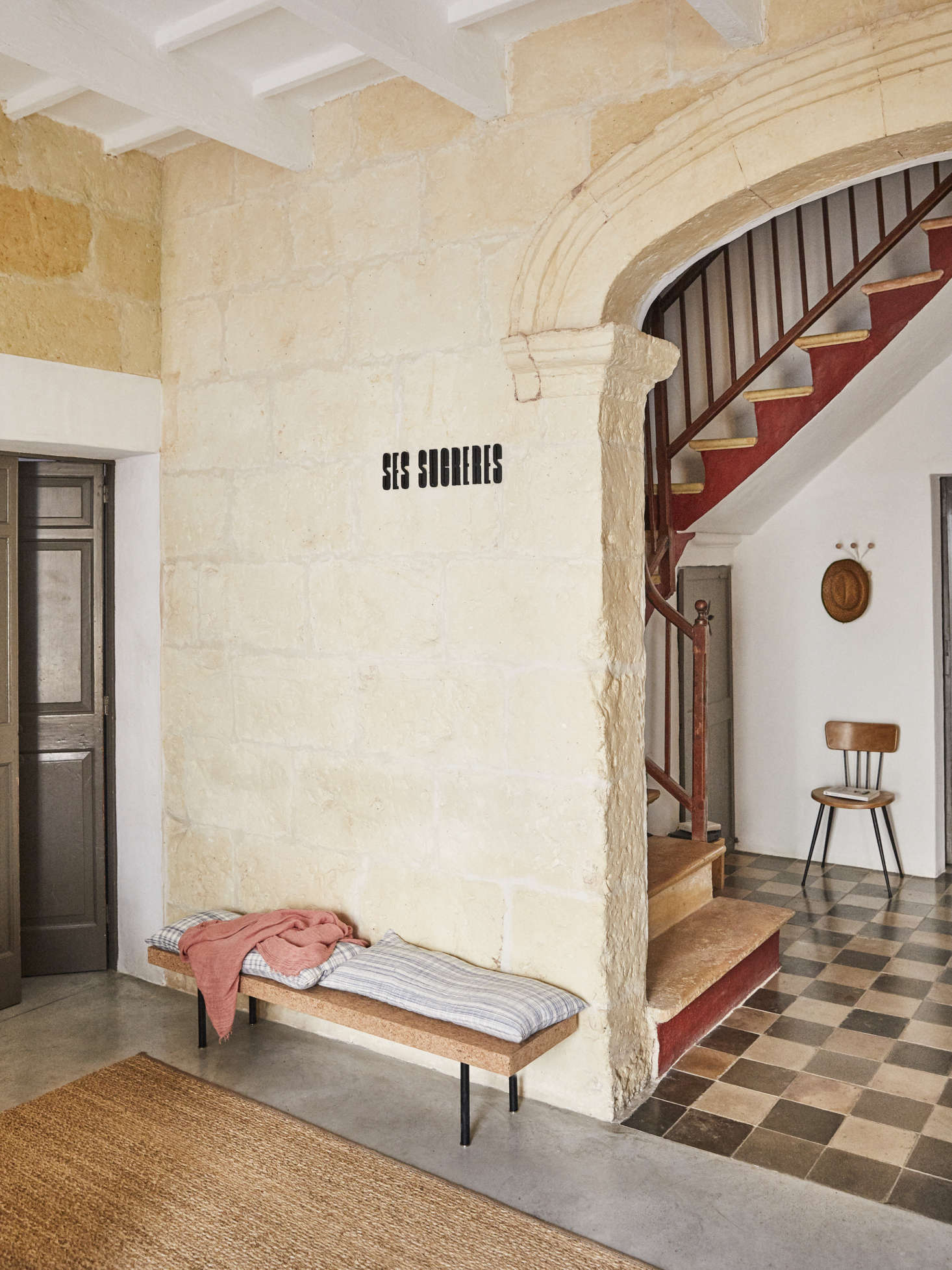 In the entry, the original stone walls meet newly polished concrete and a bench designed by Ilse Crawford for Ikea’s former Sinnerlig collection.