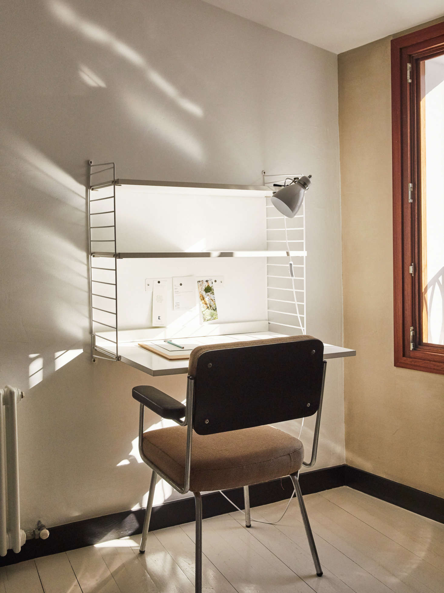 And in another room, a vintage chair sourced locally in Menorca slides up to the iconic Nils Strinning String Work Desk.