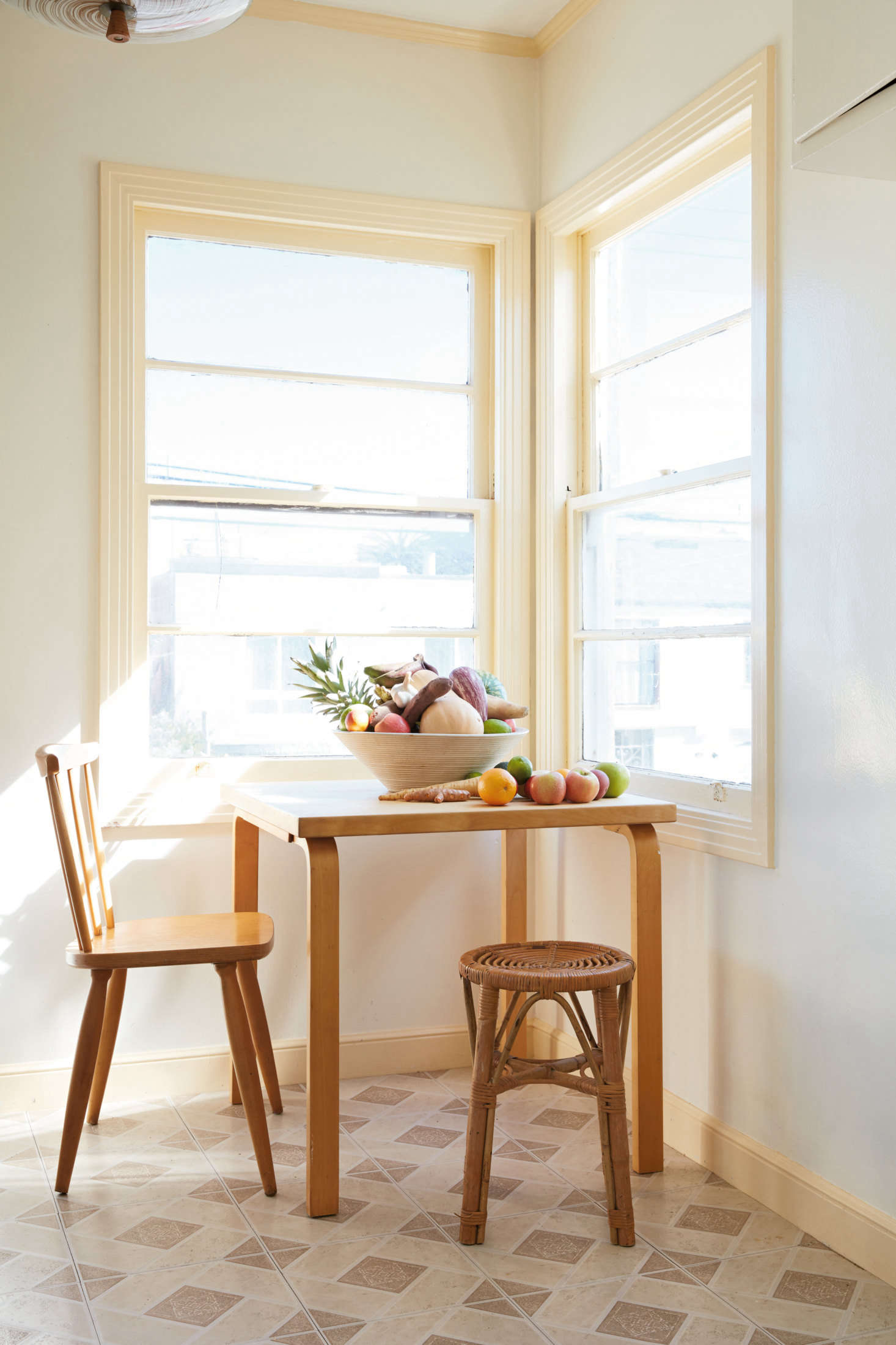 A breakfast nook in the couple’s Great Highway apartment exemplifies what they call “the mix”: furniture and fittings that “represent a sort of map of our lives and our tastes,” all tied together by a neutral palette and natural materials. Here, an Alvar Aalto table mixes with a rattan stool, a flea market find.