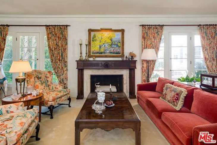 Matching florals extended from the armchairs to the curtains in the living room. The wooden mantel, preserved in the den, was one of the only original architectural details the team ultimately decided to replace.