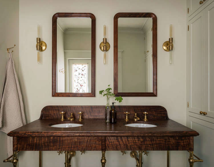 In the bathroom, a custom-designed vanity “made from some beautiful figured Western walnut” steals the show. The sconces are by Michele Varian.
