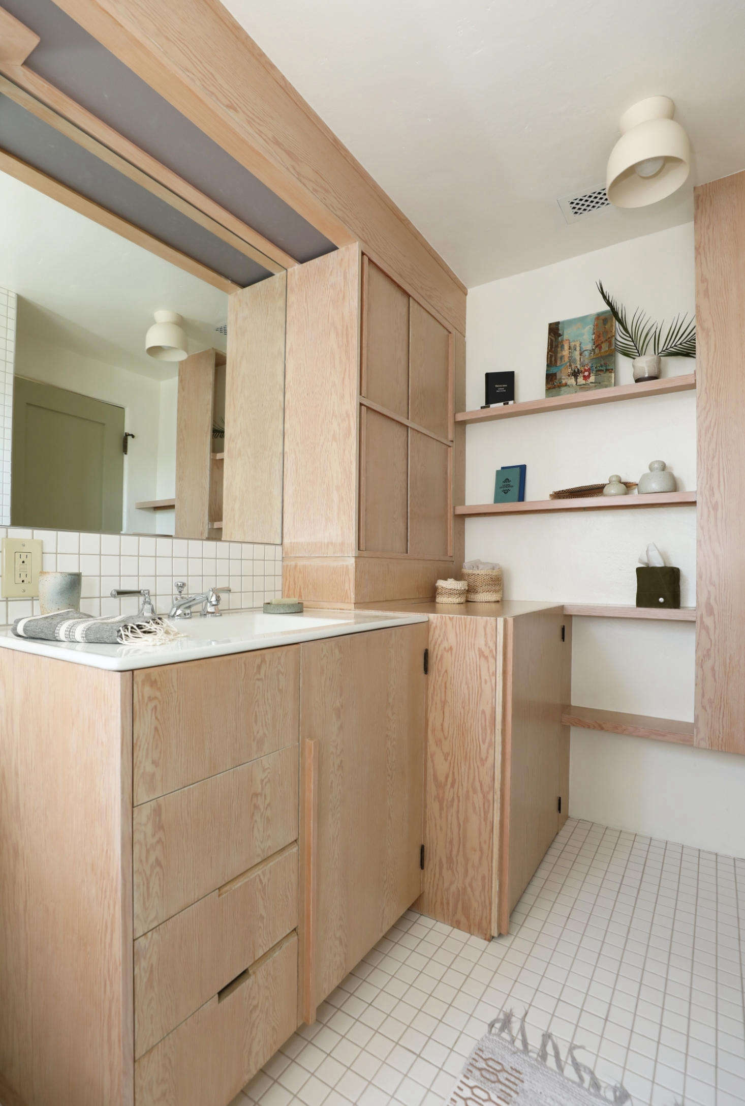 Luis Guerra Woodworking made all the cabinets in the kitchen and bath. A dual washer/dryer unit is concealed behind the deep cabinet. The Terra Surface Ceiling Light is by Cedar and Moss.