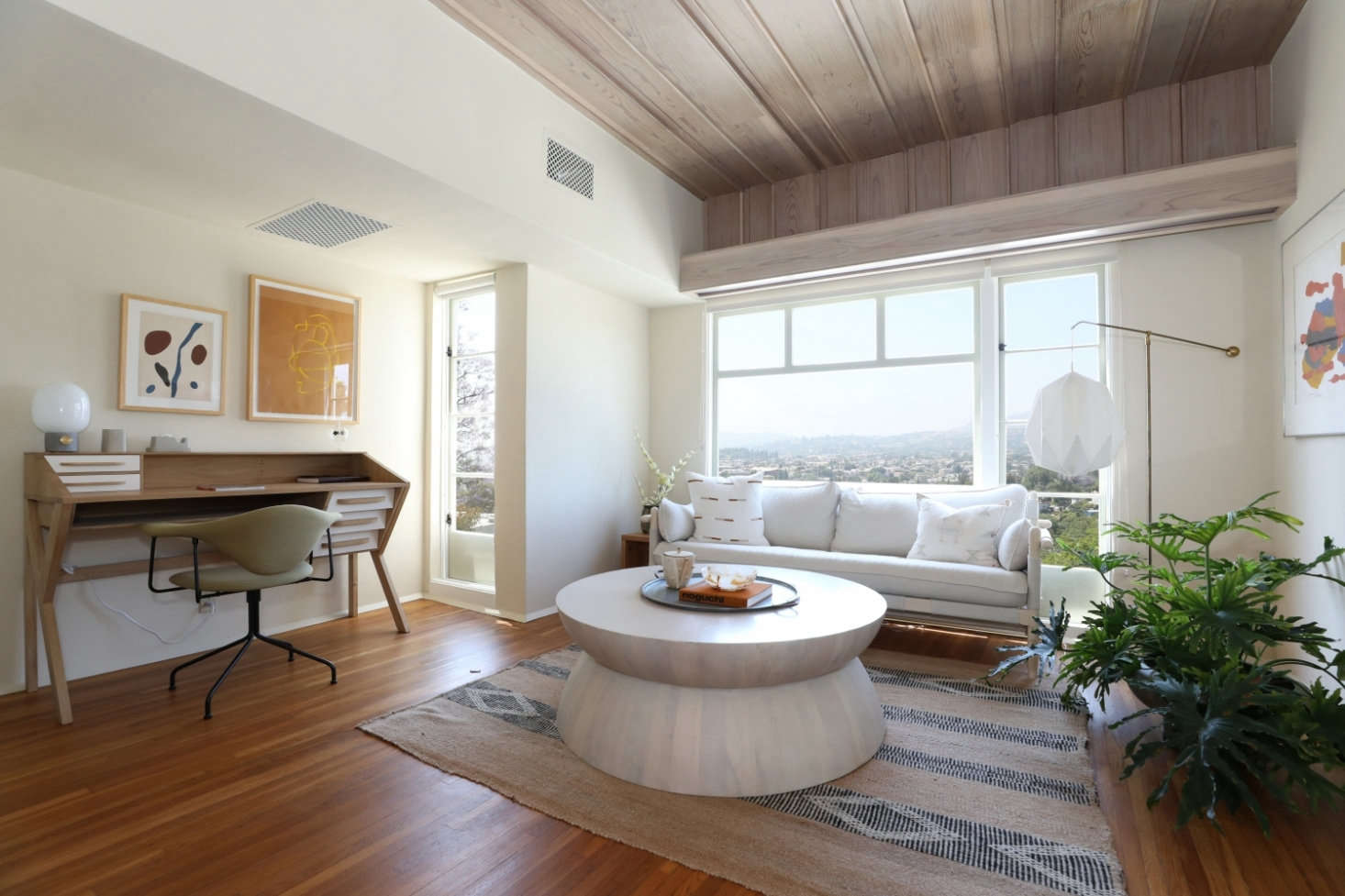 The white oak floors are original to the home. The ceiling is clad in cathedral plywood sourced from a small lumber mill in Portland, Oregon. “Cathedral plywood has the wood grain patterns that were typical of plywood from the 1920s and ’30s. It was a result of using old growth trees and the cutting blades of the period. The stain is a hand applied white wash,” explains Finegold. The Origami Desk is by Ethnicraft.