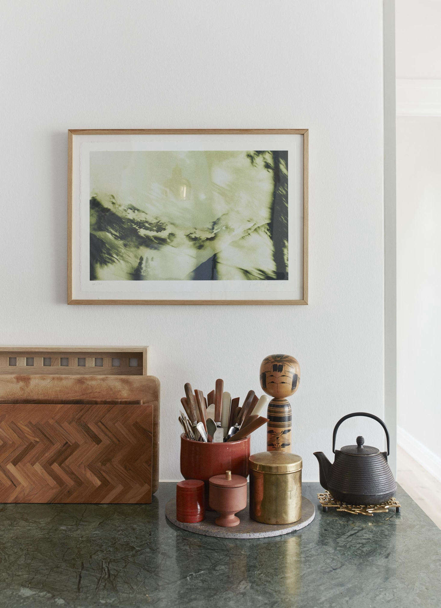 A tray corrals a few kitchen essentials, including a petite terra cotta Edge Sugar Bowl, designed by Copenhagen-based design duo Stilleben, and a vase full of utensils. (For a look at a few of the company