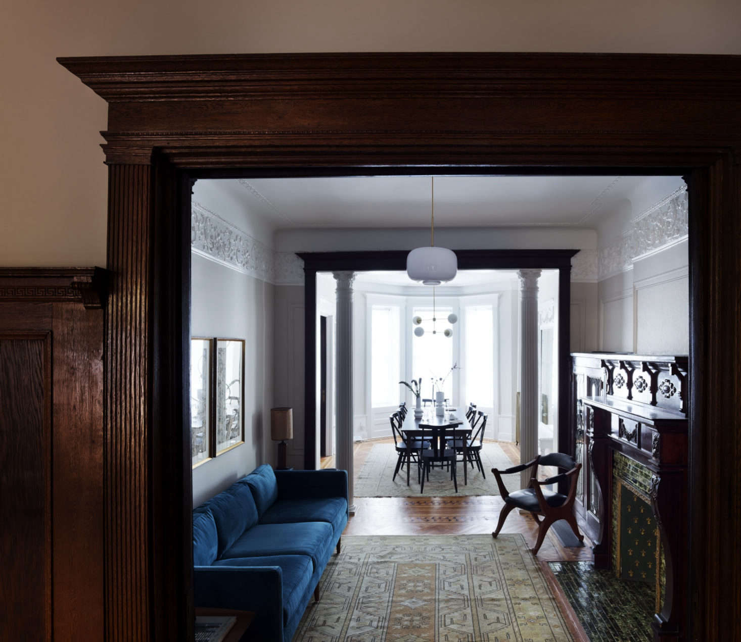 Just off the dining room is a narrow parlor, fitted with a blue velvet couch across from the original fireplace. Otherwise it’s left sparse, to allow easy movement between dining room and living room.