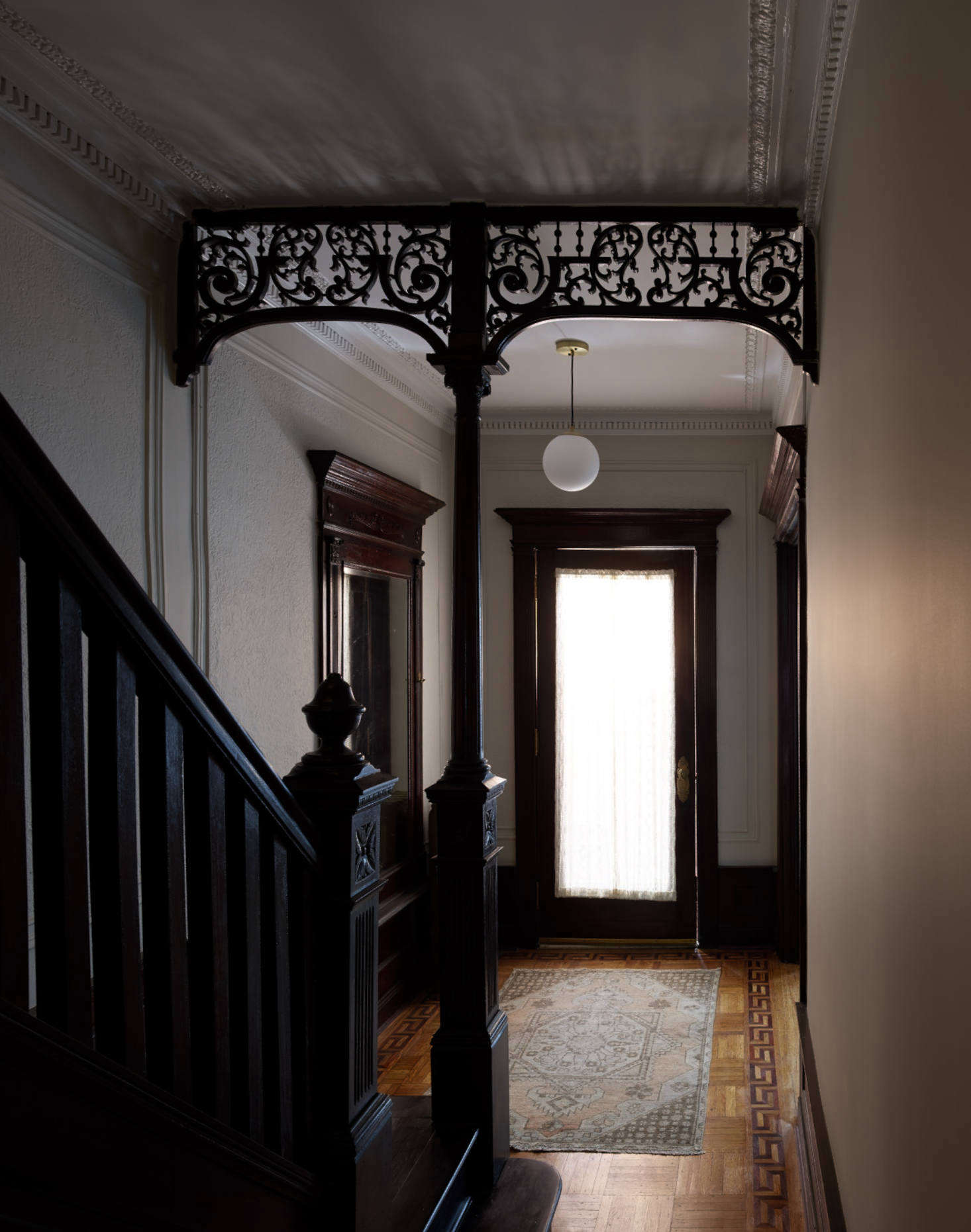 The dramatic first-floor hallway, with elaborate moldings preserved, sets the stage for the rest of the house.