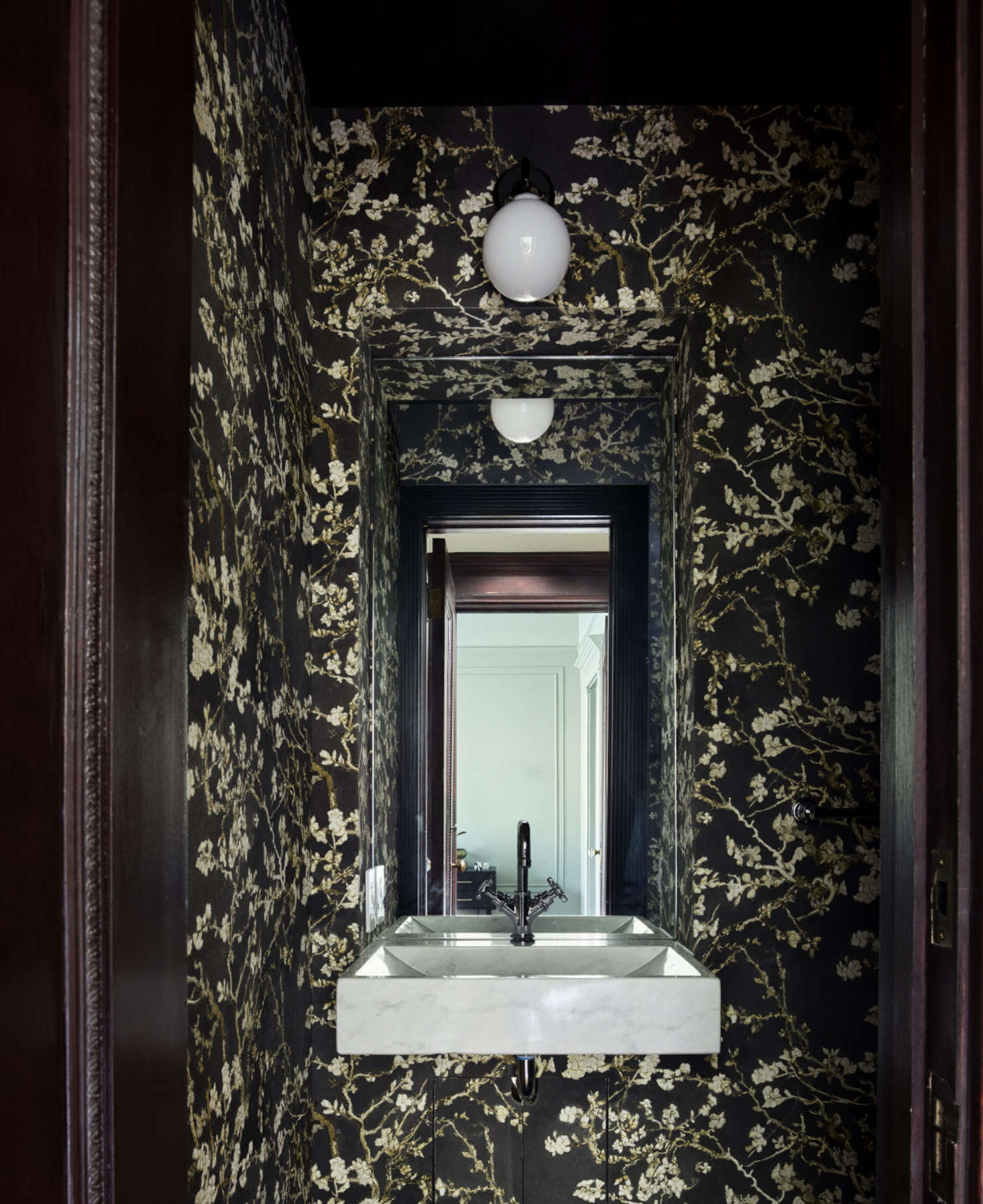 A new half bath on the second floor is papered with a floral find, “from Wayfair of all places,” Spain says. (It’s called Van Gogh Blossoming Almond Trees, in black.) “I think small spaces have the biggest potential for making a big impact.”