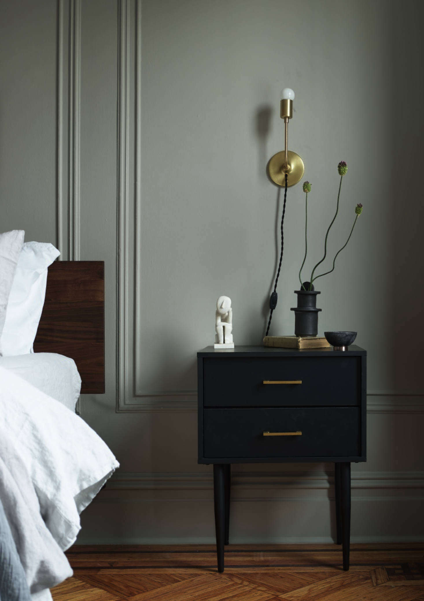 Sculptural flowers on the nightstand. The bedside lights are the Astrid Sconces from Schoolhouse.