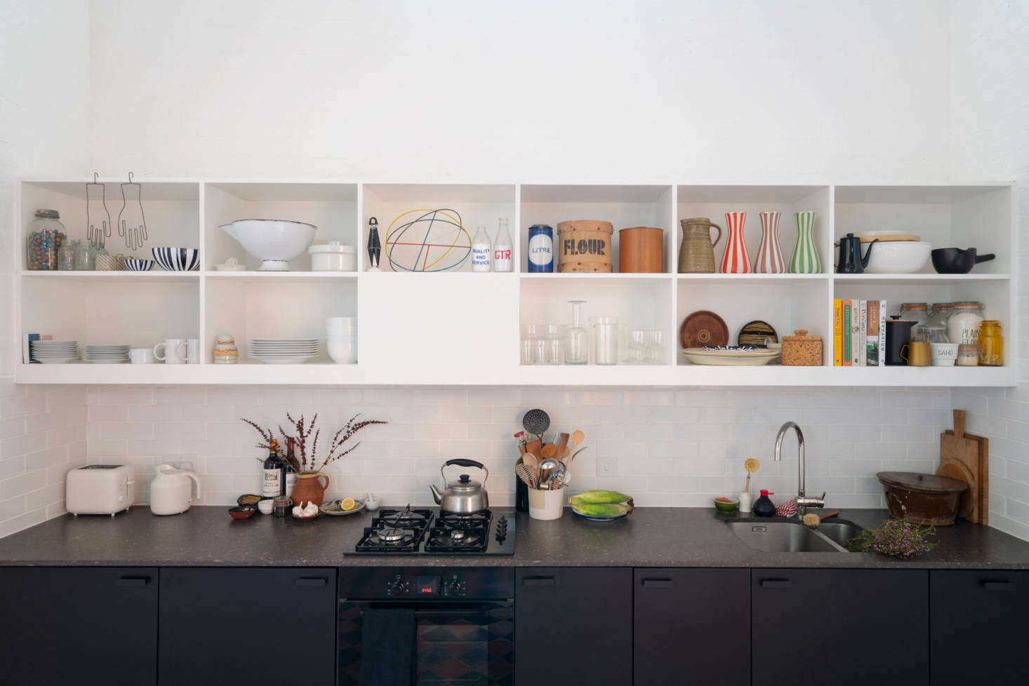 The kitchen cabinets are Ikea’s Kungsbacka design made from recycled plastic bottles and detailed with Hackas pulls ($6.99 for a two pack). The counter is Dark Concrete, a quartz from Whitton Worktops. The diminutive black stove is a Bosch.