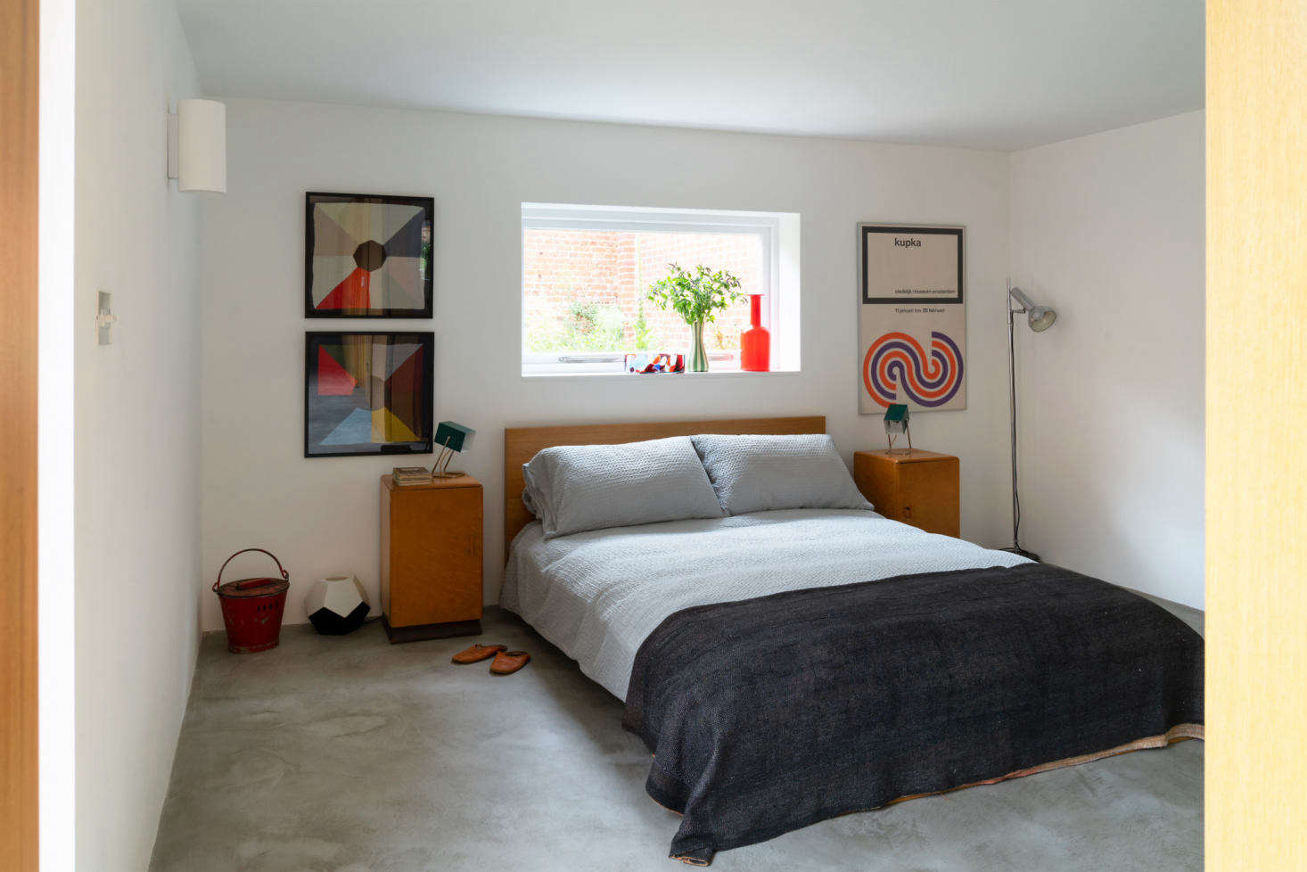 All of the rooms are painted white—”just a good, basic white, nothing fancy”—because, as Sandy points out, “there’s enough color in all the tat I’ve bought on eBay.” Among the finds in the downstairs bedroom: Kaiser Leuchten bedside lights, an orange Holmegaard vase from a thrift store, and framed collections of men’s silk pocket squares.