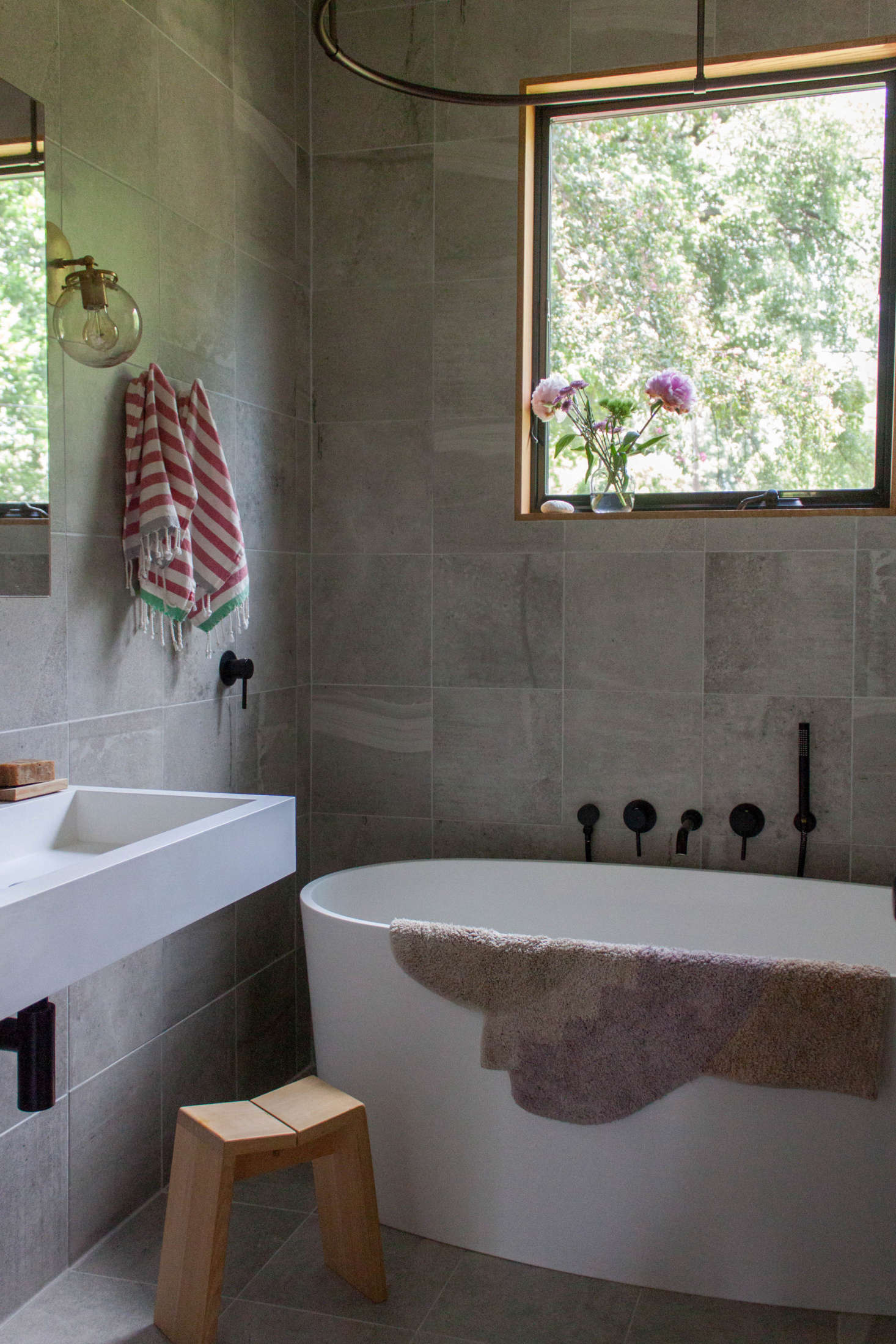 “I knew I wanted a muted palette for the bathroom, and a style that leaned toward modern but wasn’t stark,” says Gabi. The sink and bathtub are by Badeloft. The lighting is by Triple Seven Home, and the Hinoki stool from Nalata Nalata was a gift from her father-in-law.