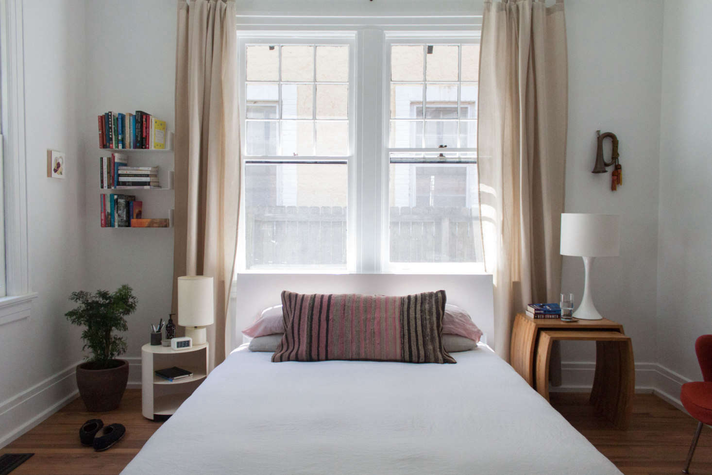 The couple’s bedroom has ample light thanks to two exposures. And, as in the other rooms in the house, books and art are prioritized (the couple own a bookstore in town called the Book Tavern). Here, their books are organized on wall shelves by Tee Books.