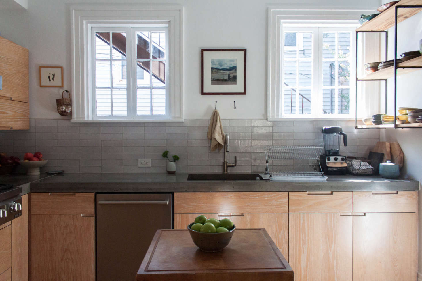 “Other than the bathroom, the kitchen was the only room that was fully gutted. My father-in-law helped us figure out the best use of space, and even then we added the butcher block island because we could use the extra counter space,” Gabi tells us. “The cabinets are custom, as are the concrete countertops. I try to balance out all of the warm wood tones with art and pottery.”