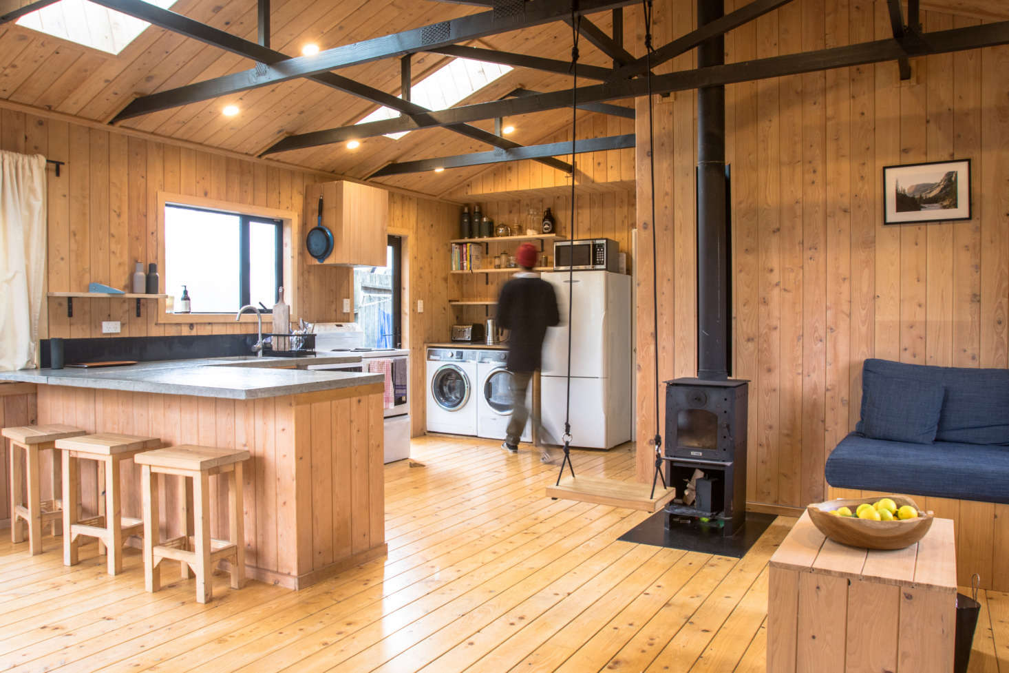 George describes the look of the interior as “a mixture of a forestry cabin and ski lodge” and says “macrocarpa has such a nice smell—it’s very welcoming and everyone who comes in for the first time comments on it.” Work was done on the 100-square-meter (1,076 square-foot) interior in a busy six-week stretch, and then George and Hannah moved in; over the course of the following two years, the exterior was finished during weekends and vacations.