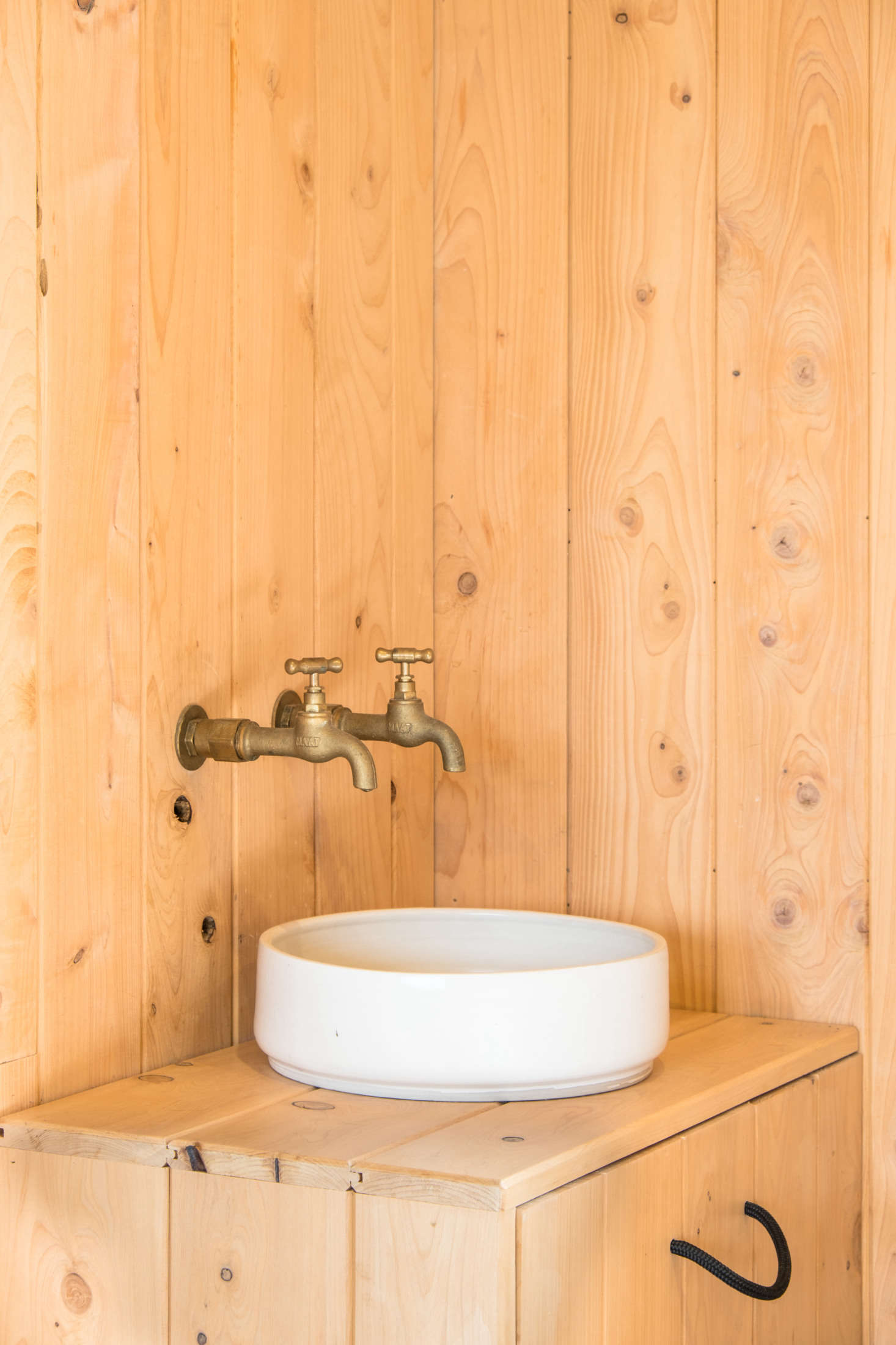 “When we were lining what had been the garage, there were two taps from an old laundry sink, so we decided why not have a sink in the bedroom for brushing teeth and getting water,” says George. “Will had just made the basin at a pottery course and it was perfect for here; we added the surround for storage.”