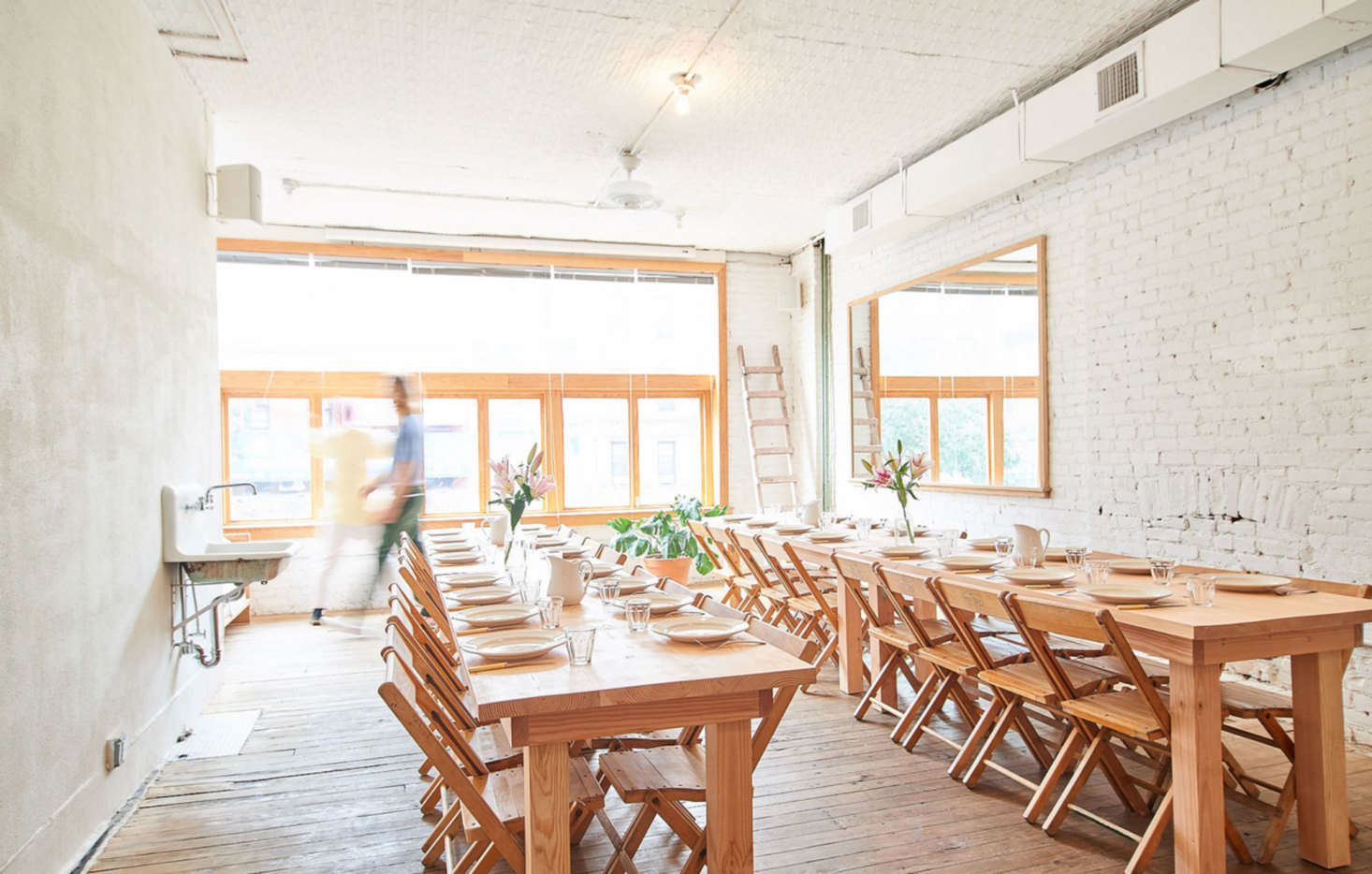 Large windows and oversized mirrors provide plenty of light. “The tables are actually designed to fold down for storage, even though they don’t look like they fold,” says Poe. The vintage folding chairs were sourced online.