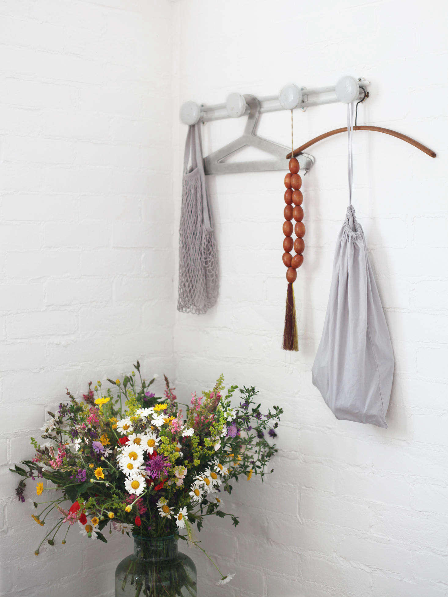 A pair of vintage French metal hanging rack flank the bed in the brick-walled mezzanine.