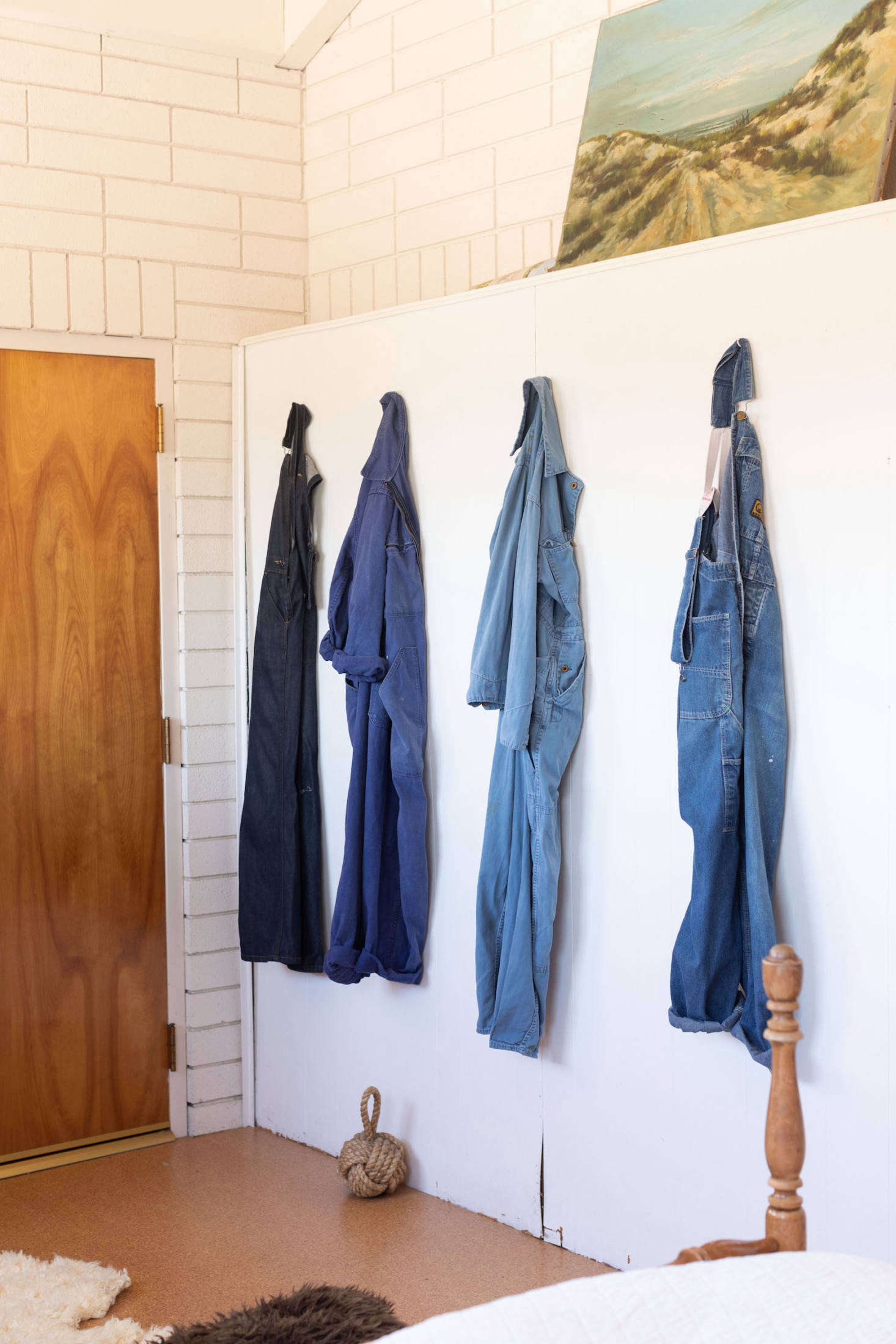 A row of work overalls and jumpsuits create a beautiful vignette.