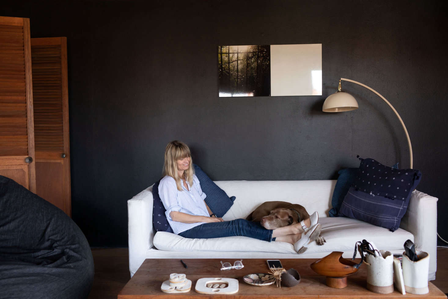 Wilkinson, a British transplant, with her loyal sidekick, Brownie. Displayed on her coffee table are some of her ceramic works. Her home is situated high up in the hills and rests under the glare of direct sunlight; dark interiors offer a cool respite.