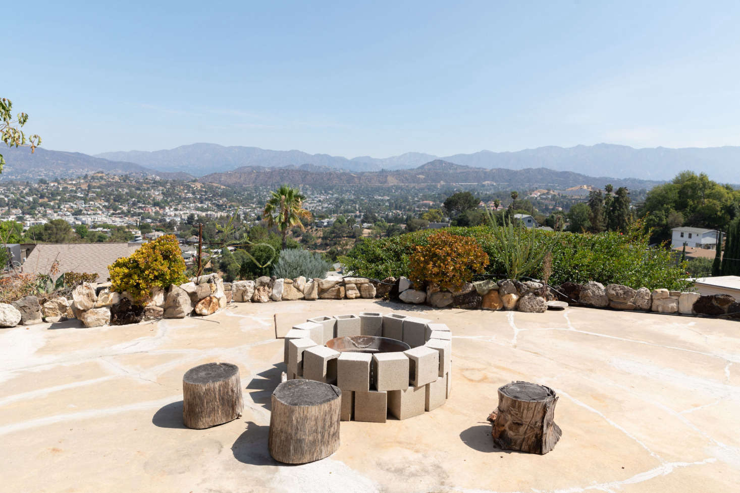 A cinder-block-formed firepit is surrounded by stumps-turned-stools.