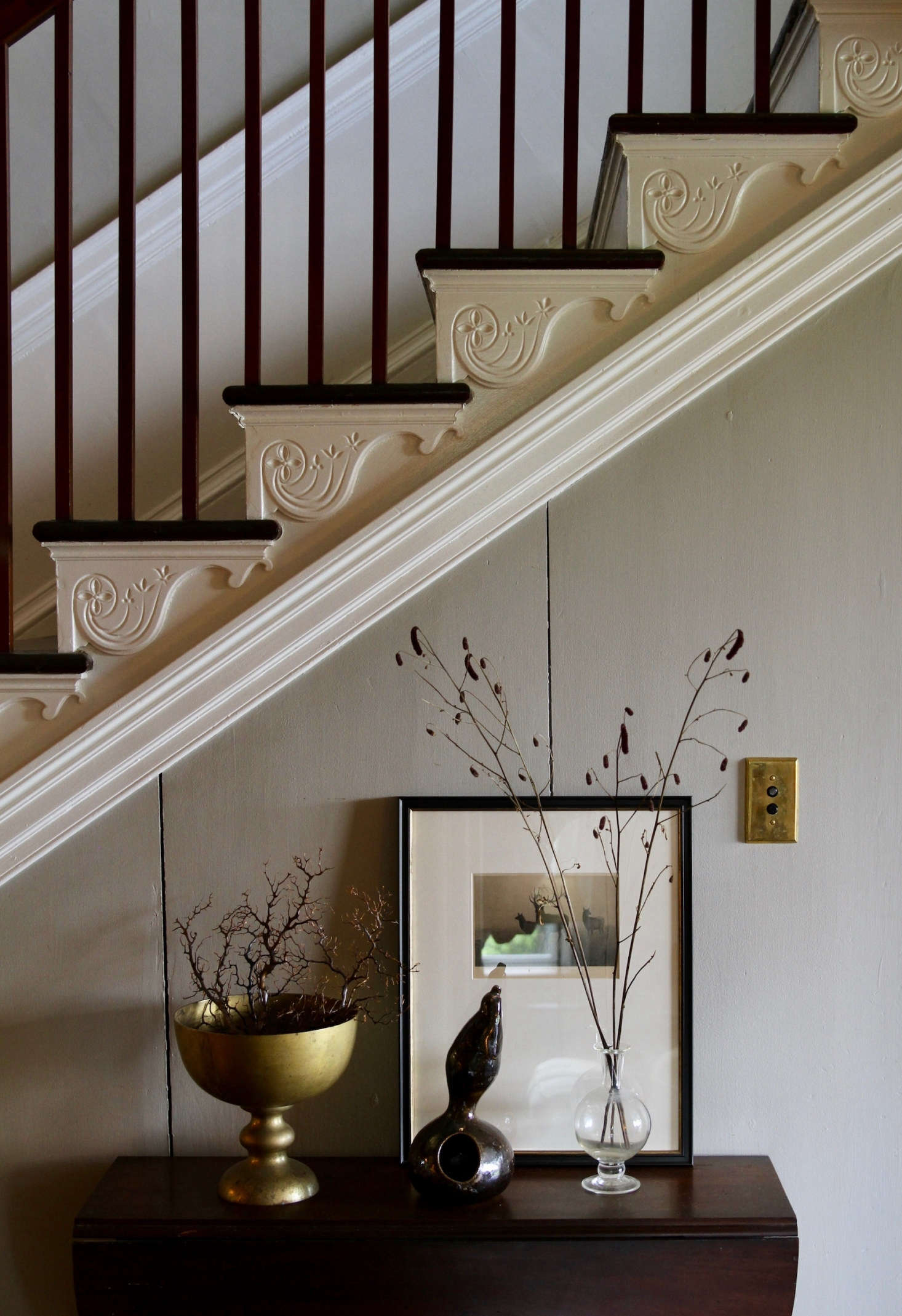 While the couple didn’t have to add back in architectural details, they did have to update the home for modern conveniences. On their contractor’s to-do list: “All new plumbing, electrical, HVAC systems, relining nine fireplace flues, rebuilding massive chimneys, repairing the original slate roof, creating and updating en-suite bathrooms with radiant floor heat, refinishing all the floors, and painting every inch, inside and out,” says Scott. The couple actually ended up painting many of the interior walls themselves. Here, in the center hall, the walls are painted Benjamin Moore’s Northern Cliffs.