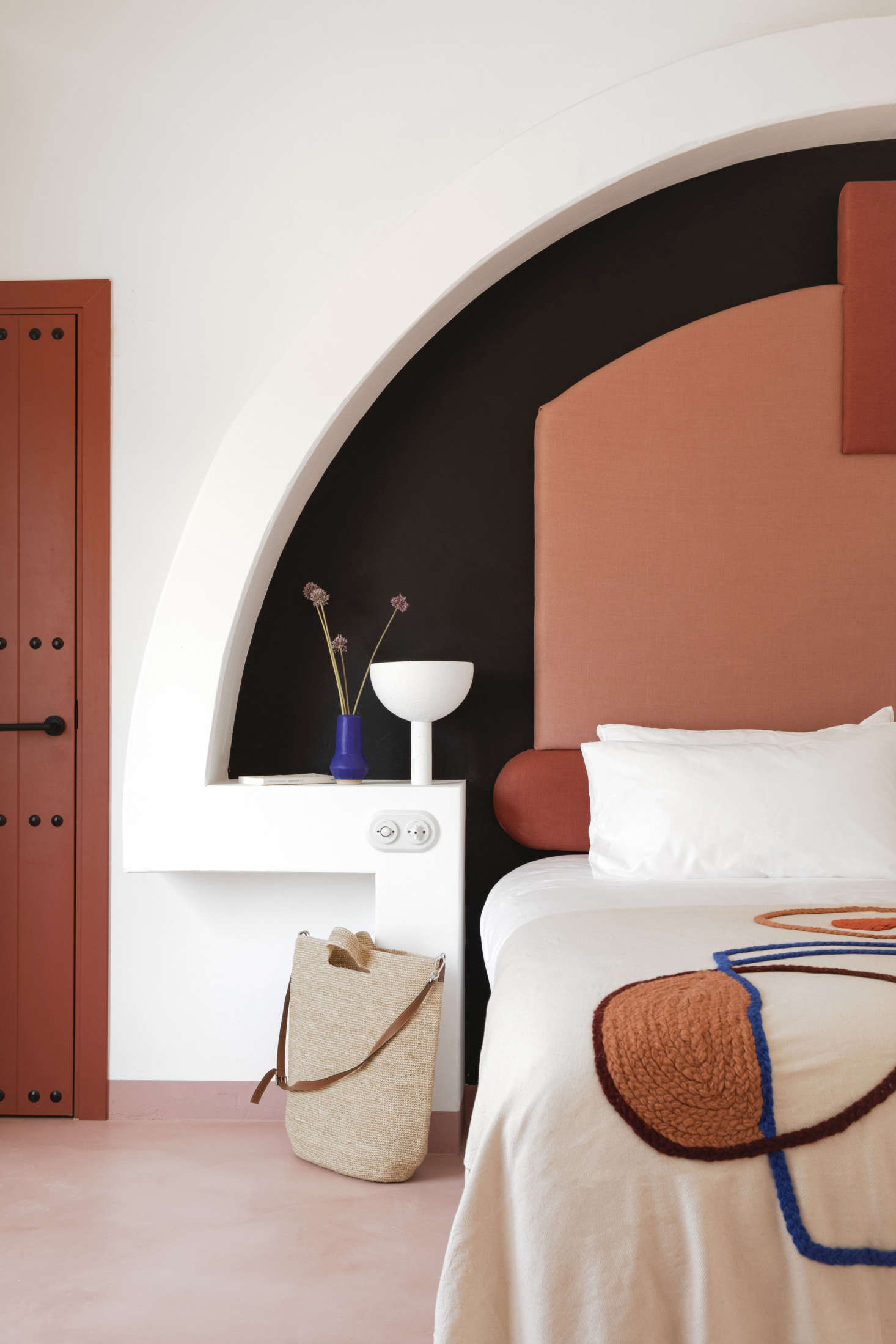 “I wanted to do something very drawn with a lot of shapes but very simple shapes,” Meilichzon says of the headboards. This room has a microcement floor.