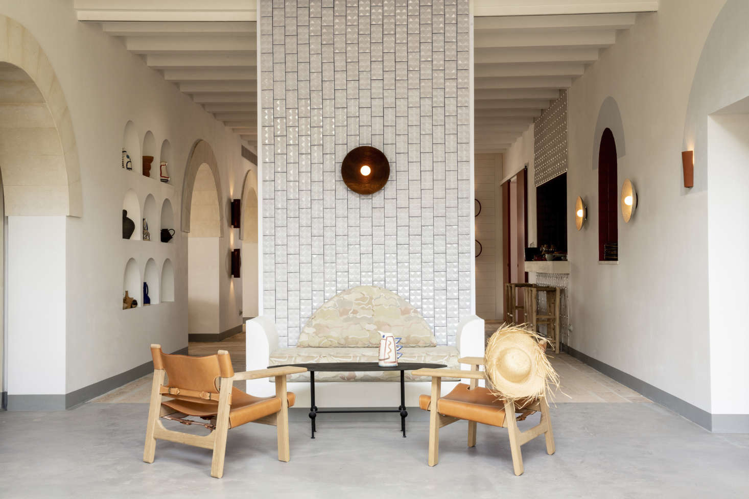 In the lobby, Portuguese tiles line a dividing wall with a seating ensemble that includes Borge Mogensen Spanish Chairs and a concrete banquette that echoes the lines of the surrounding archways. Meilichzon put teams of local craftsmen to work on the custom furnishings.