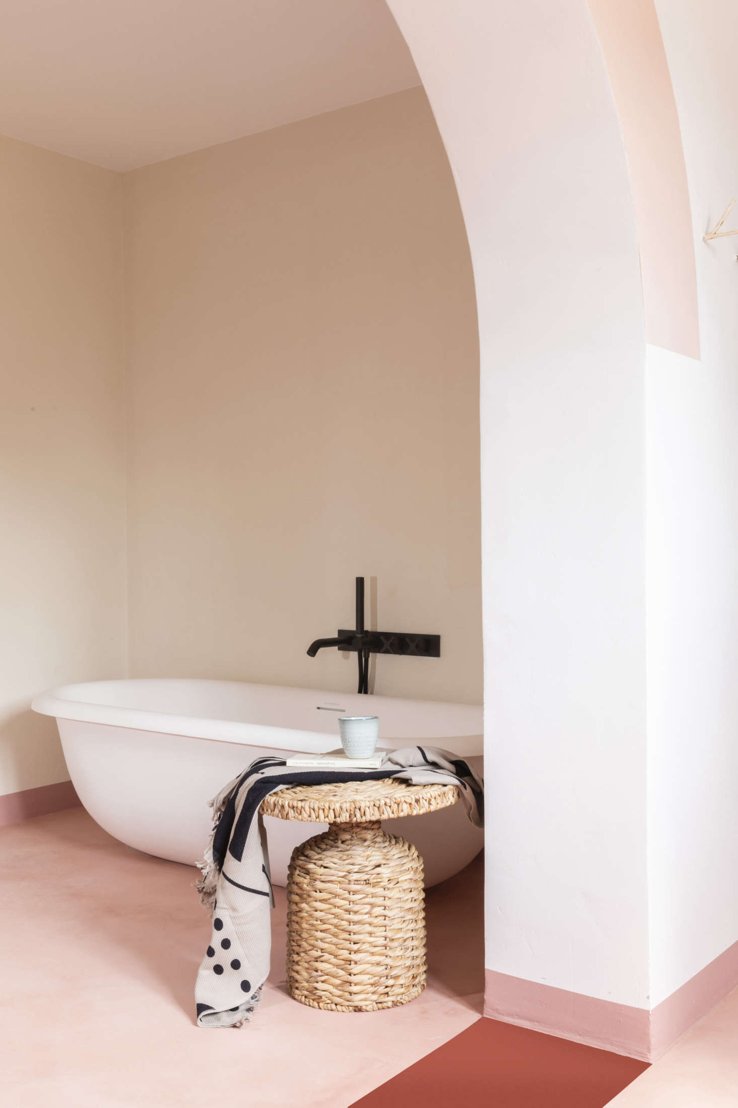 A freestanding modern tub, the Evolve Bath 1850 from British company Claybrook, is set in its own niche. The two-toned floor is microcement.