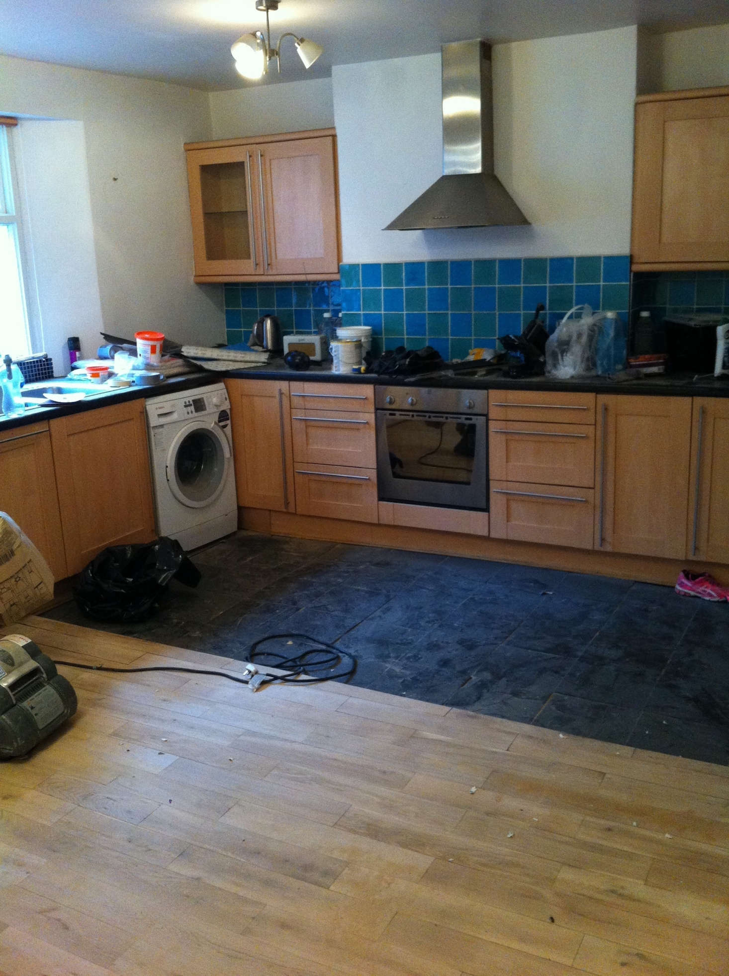 The former kitchen with dated cabinets and inelegant flooring.