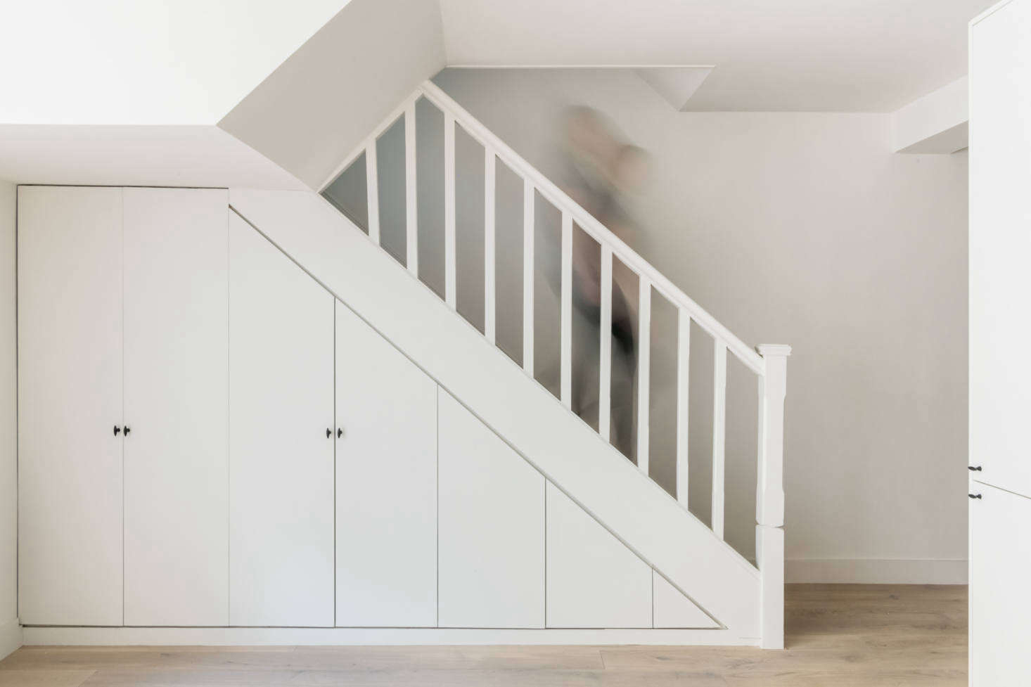 The cast iron pulls show up here on closets integrated into the staircase. The flooring is engineered oak by Havwoods. 