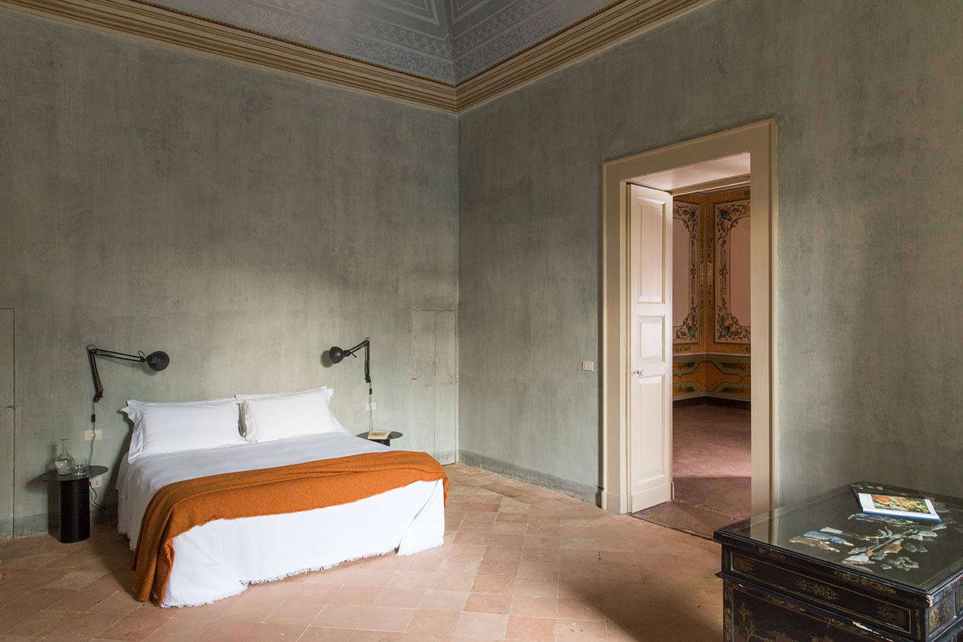 A suite bedroom in hues of pale blue and persimmon.