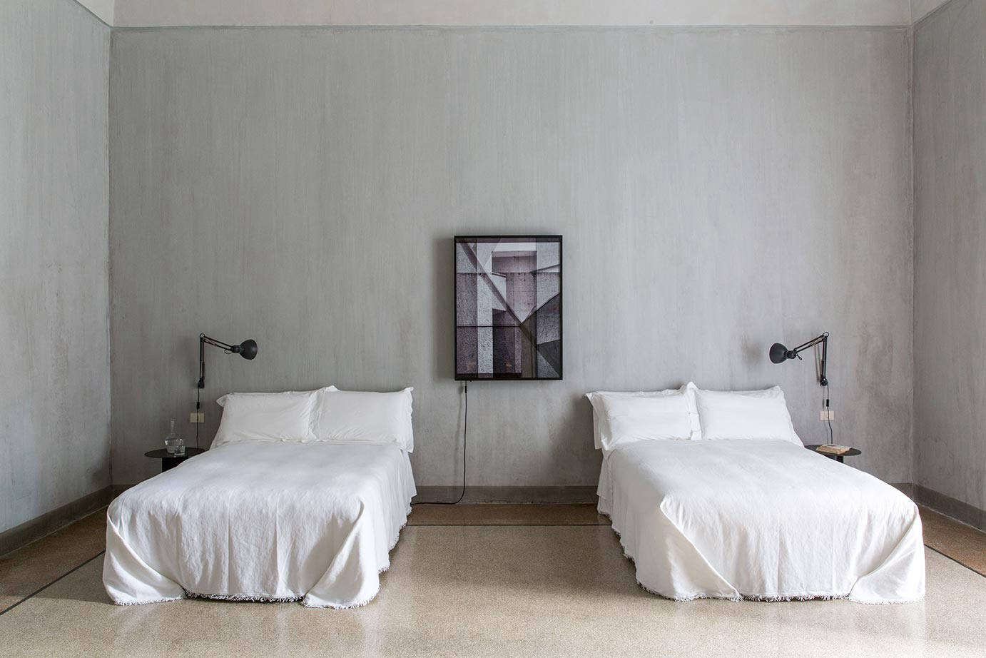 Many of the rooms feature light boxes by the artist Simon D’Exea. This one has two spare double beds, neatly made.