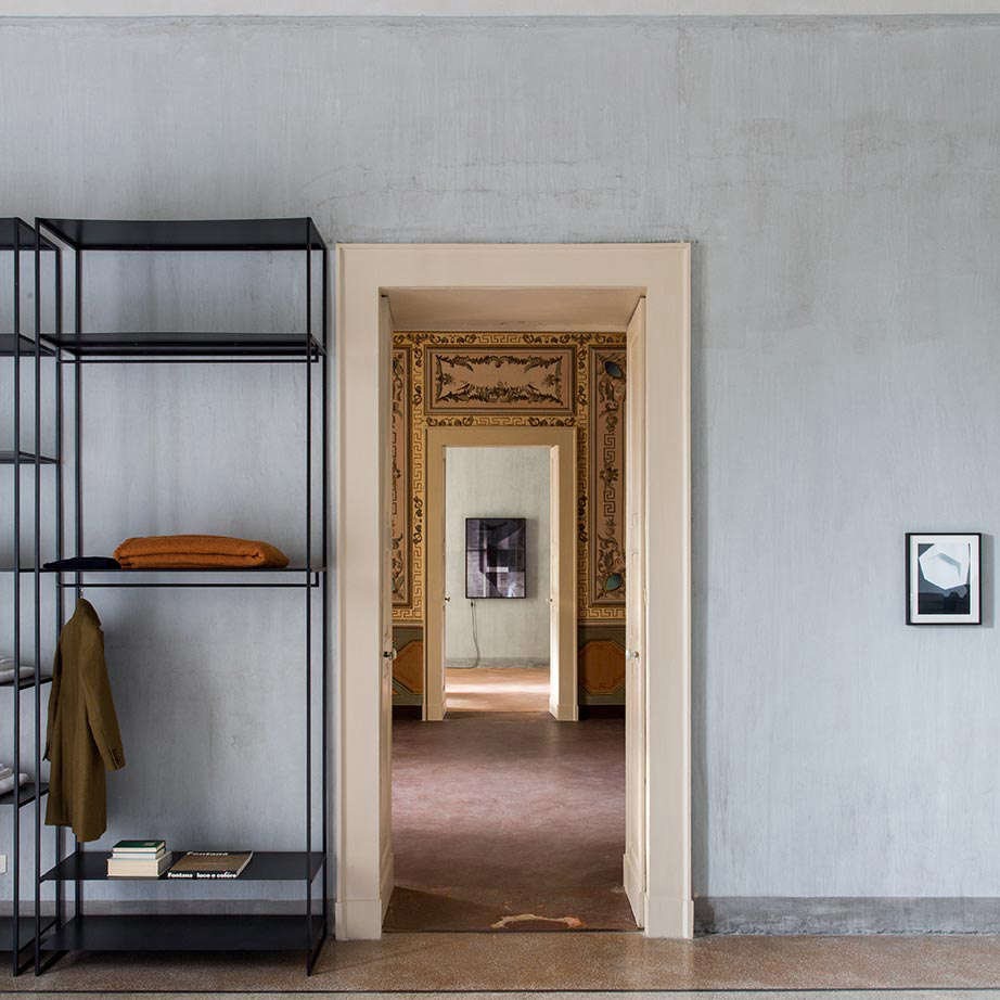 In another suite, original textured walls, left bare, mixes with a clean-lined open wardrobe.