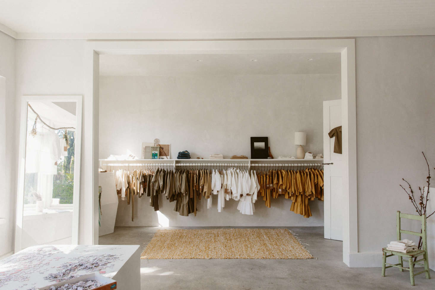 O’Rourke uses doorways and windows as opportunities for framing rooms and vignettes. Here, a wide, ceiling-high opening—set off by a floor mirror, at left; a small chair, at right; and a natural-fiber rug beyond—creates a thoughtful composition. The focus is always O’Rourke’s plant-dyed clothing for children and adults, dyed with natural materials and sewn in LA.