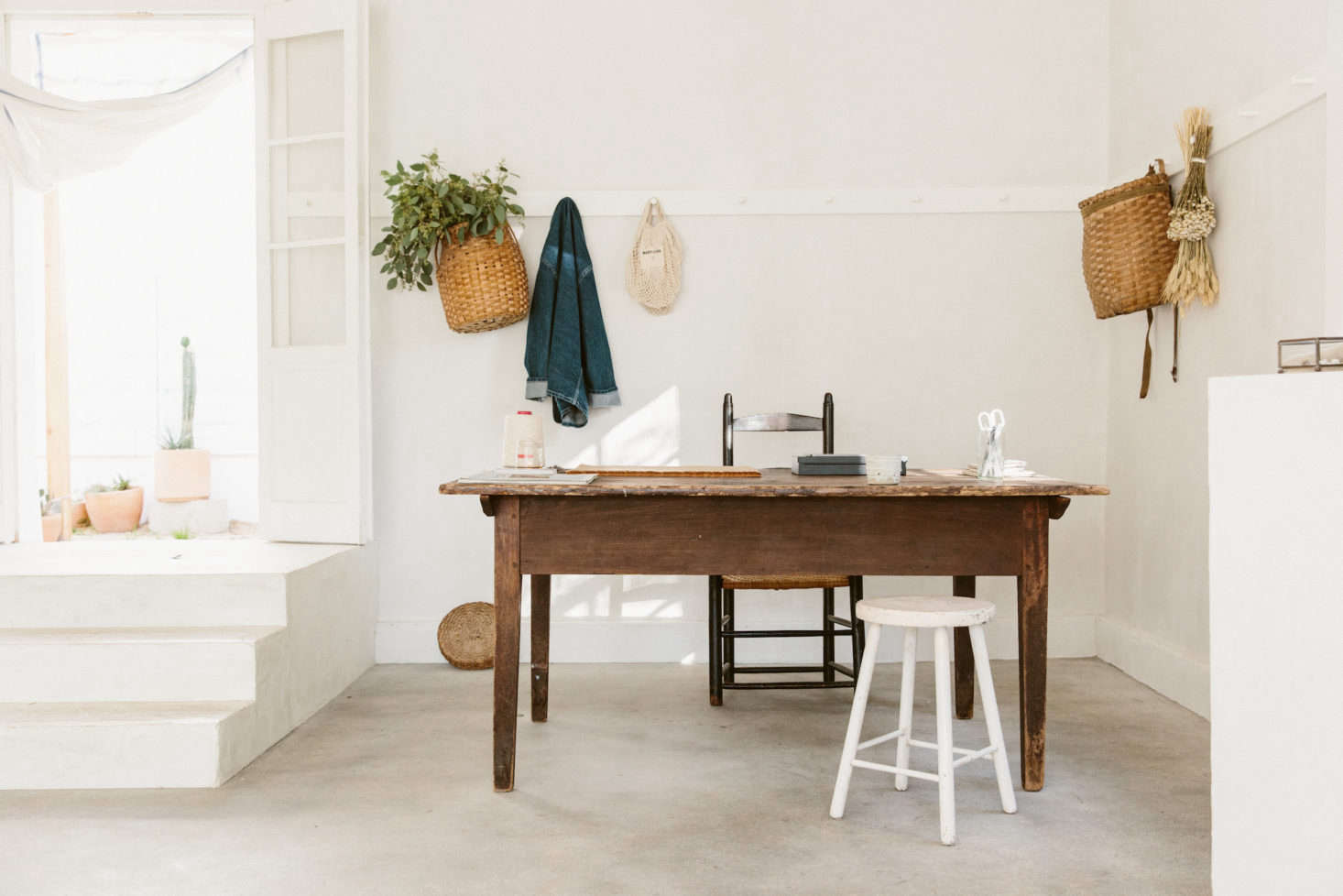 A small desk area in the back of the shop is surrounded by another New England touch: Shaker peg rails, painted white.
