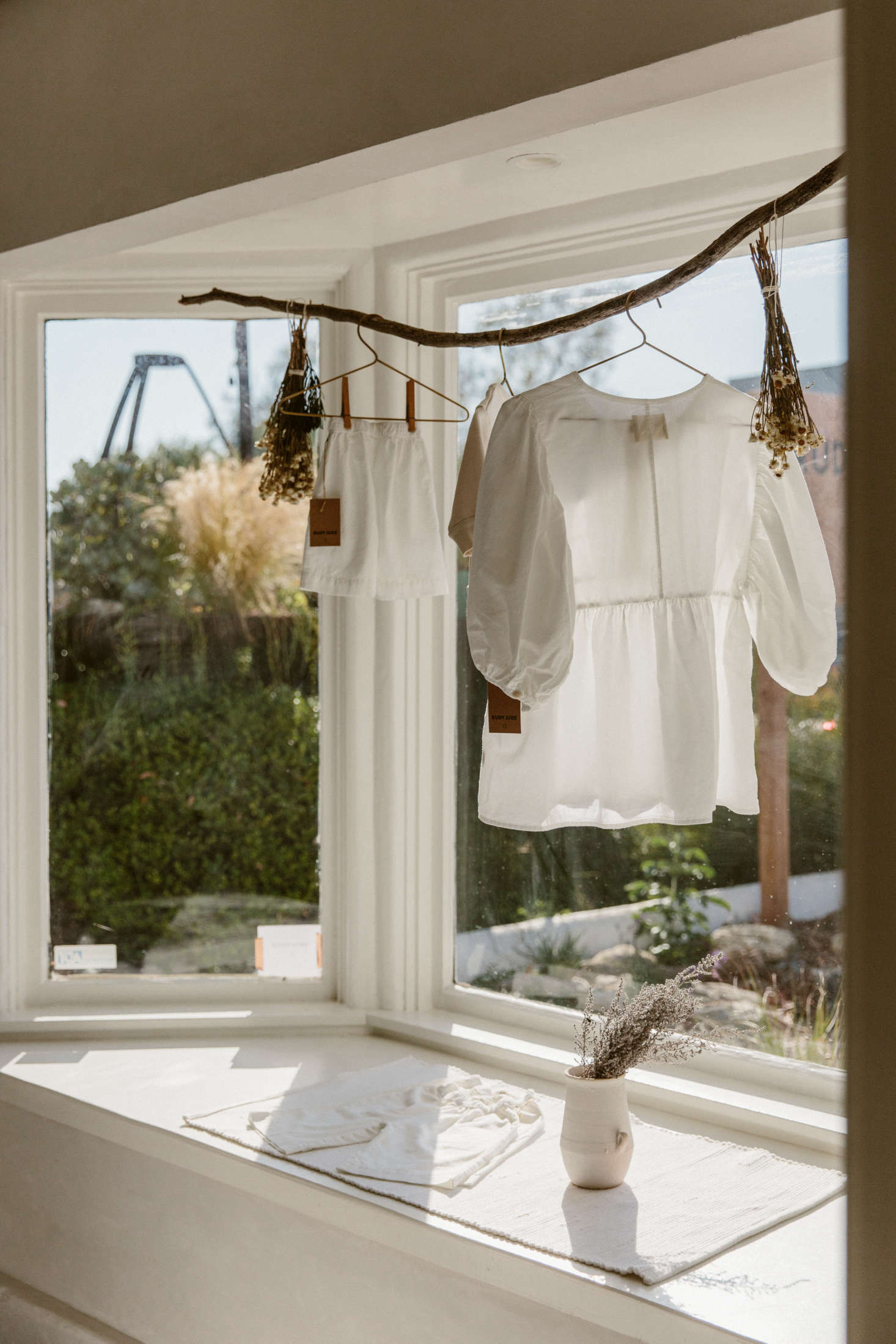 In the front window, a curved branch displays a Rudy Jude Day Blouse—and bundles of dried flowers. (For more ideas like this, see The New Rusticity: 11 DIY Ways to Use Branches Indoors.)