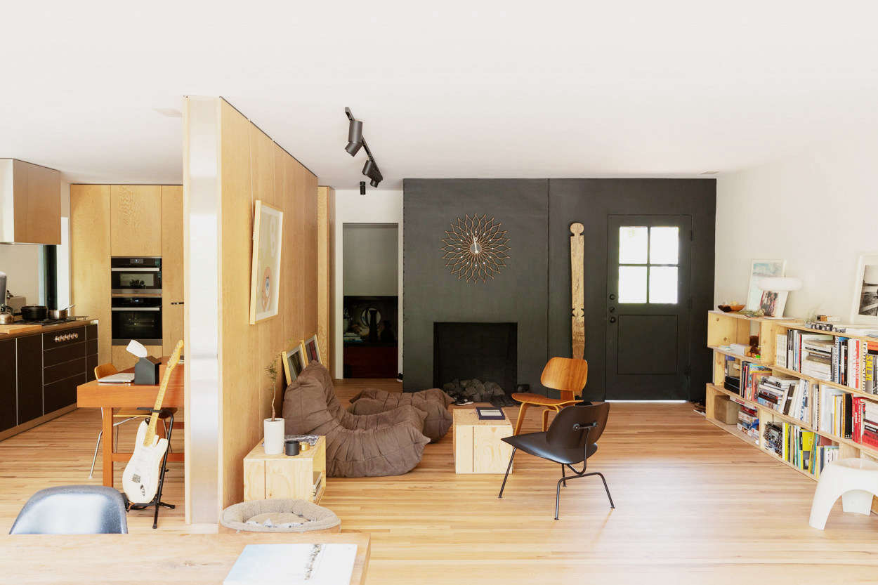 The living room is on the other side of the stainless-steel-edged partition.
