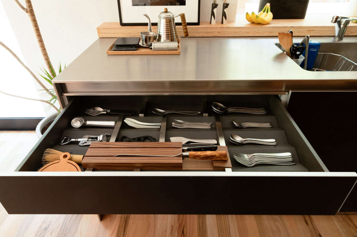 The family’s dream cutlery drawer. Their coffee pot, the Kalita Wave Drip Kettle, and other coffee accessories rest on a wood tray from Muji.
