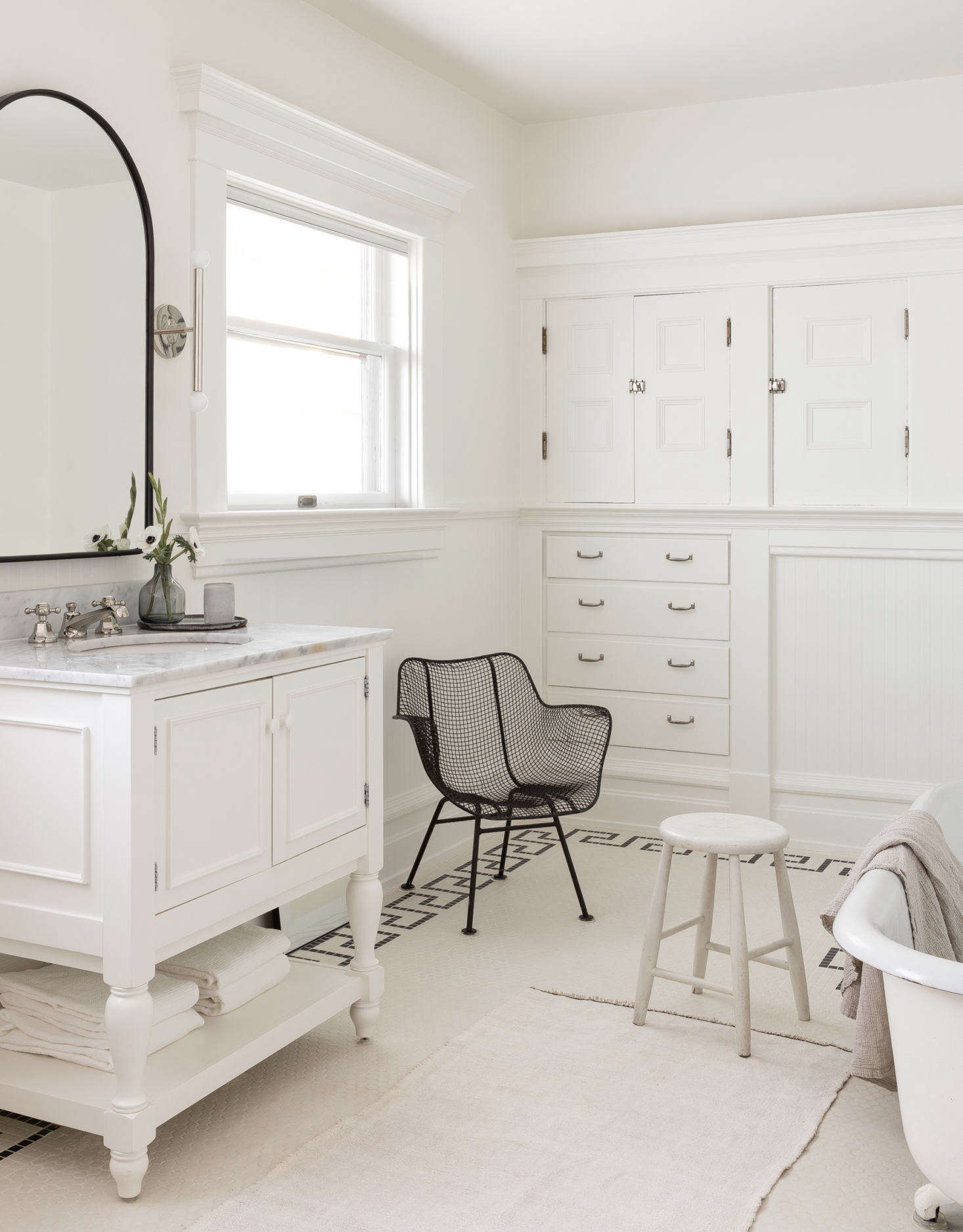 The family bath has its original built-in drawers and cabinets on two sides, but the room was updated in the 90s, when the sink vanity and tile floor were added (the latter was in bad shape and required new grouting—
