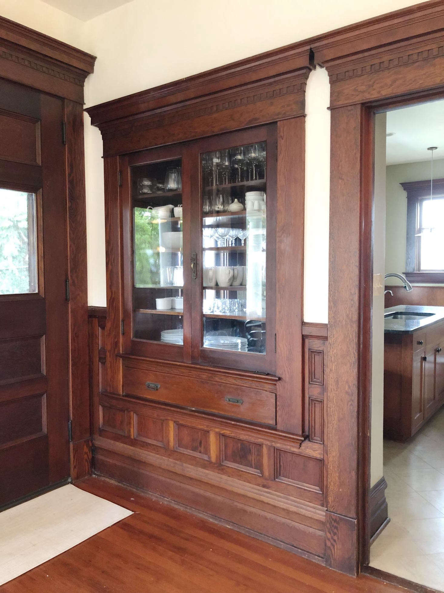 A glass-fronted cabinet is conveniently accessible from both dining room and the kitchen. Photograph by Hillary Straatman.