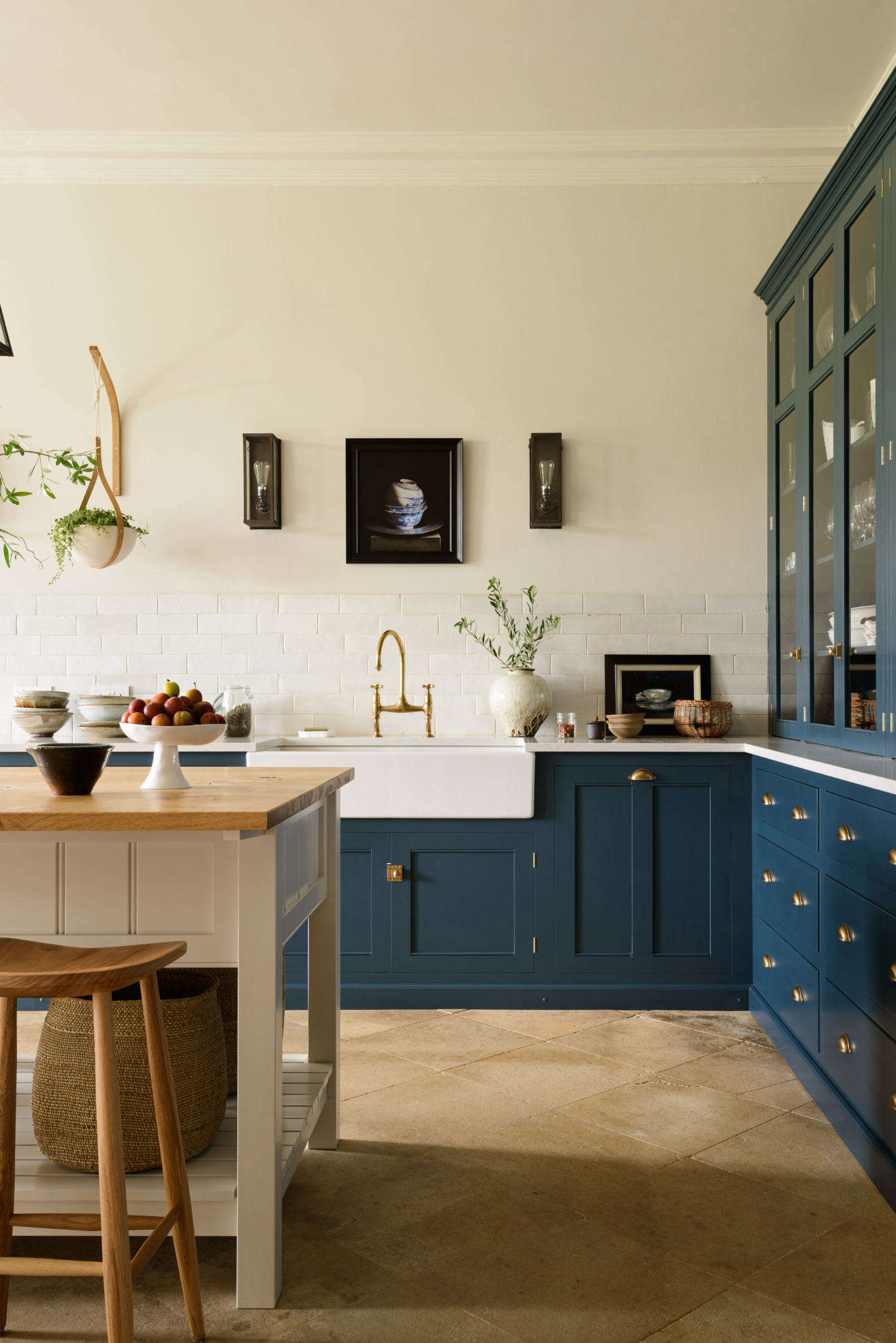 The kitchen island, painted off-white, is topped with oak. The Bum Stools are from deVOL.