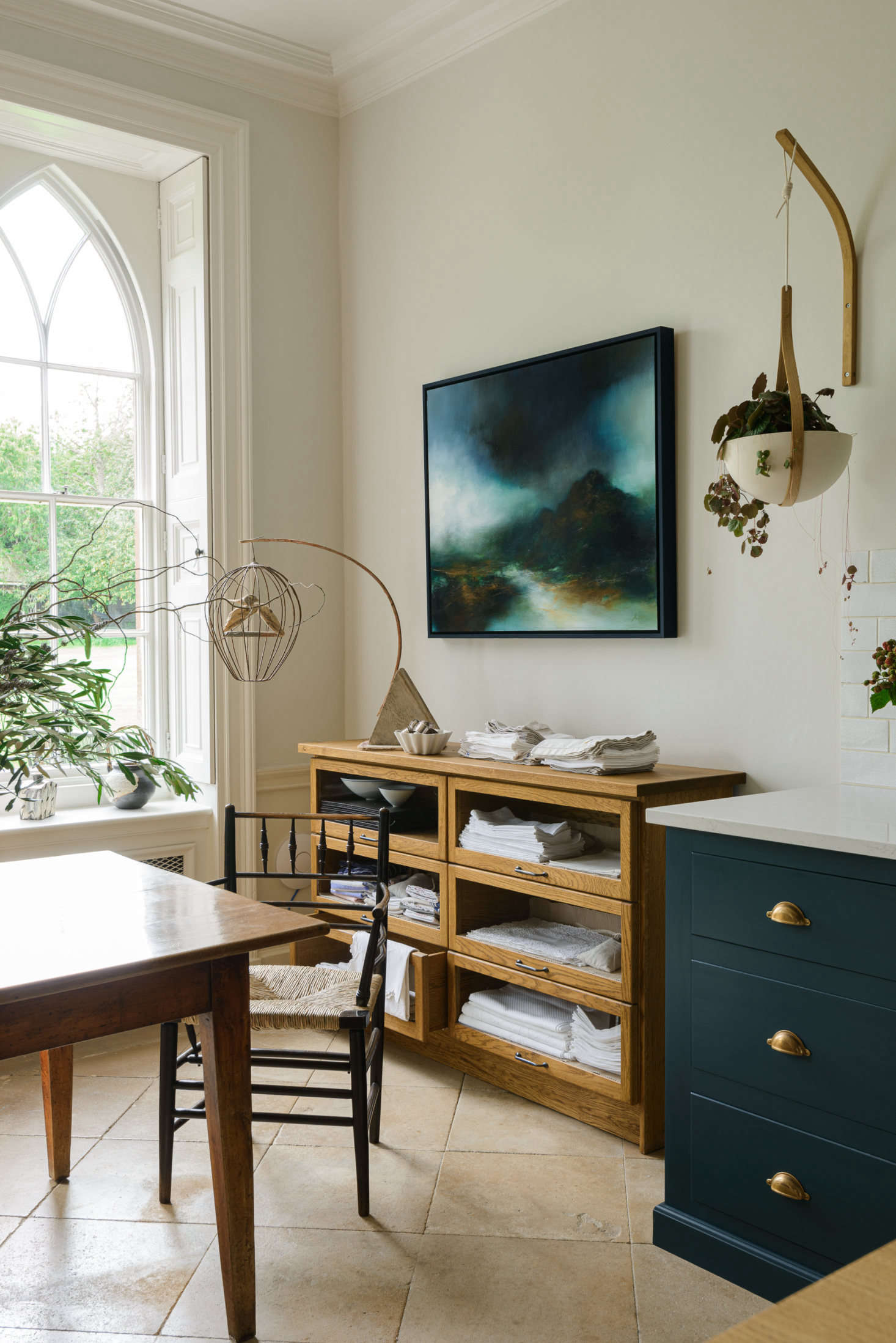 The glass sideboard, for storing kitchen linens, is from deVOL