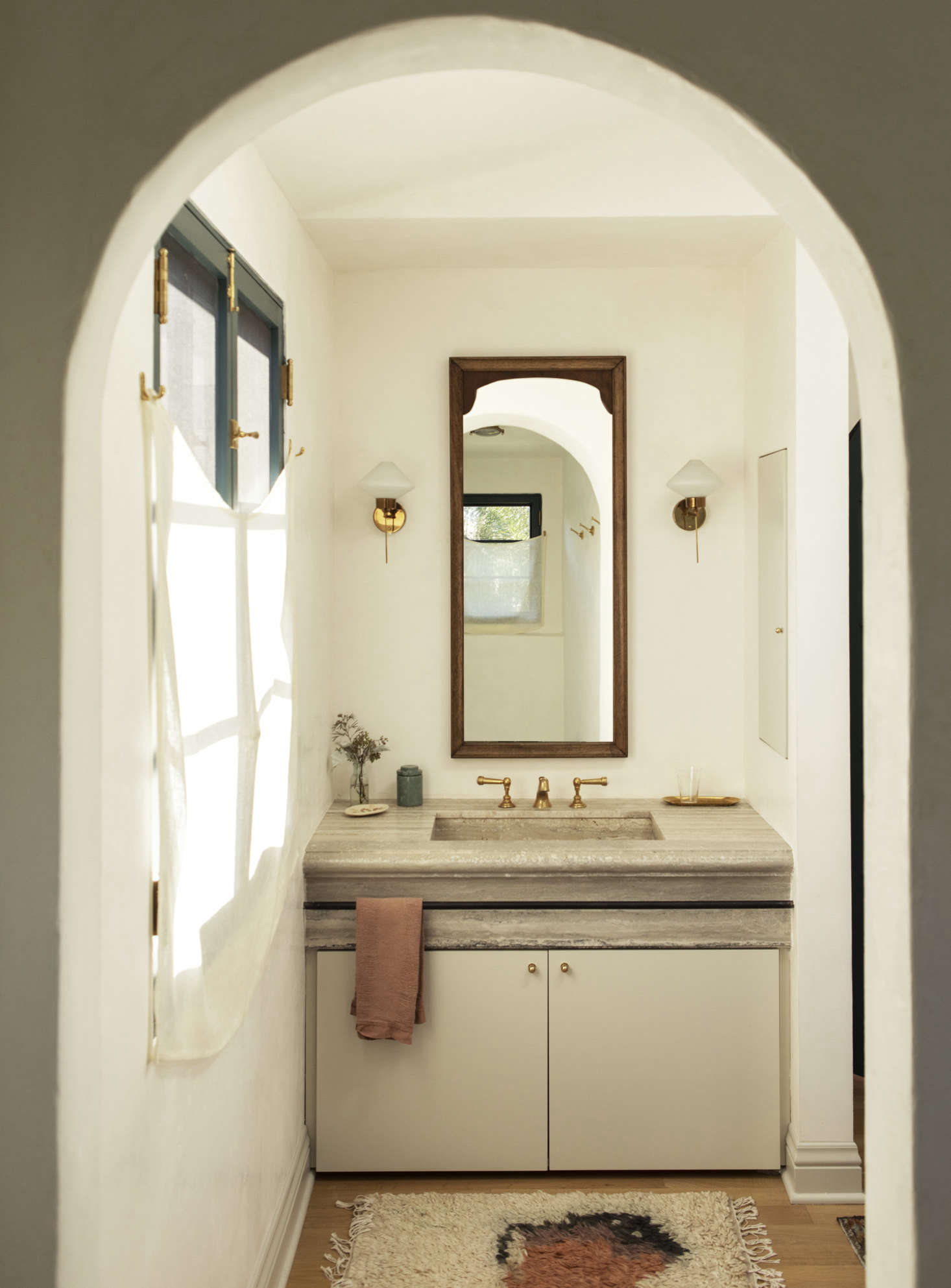 The walls have a waxed Venetian plaster finish and the sink is made of silver travertine.
