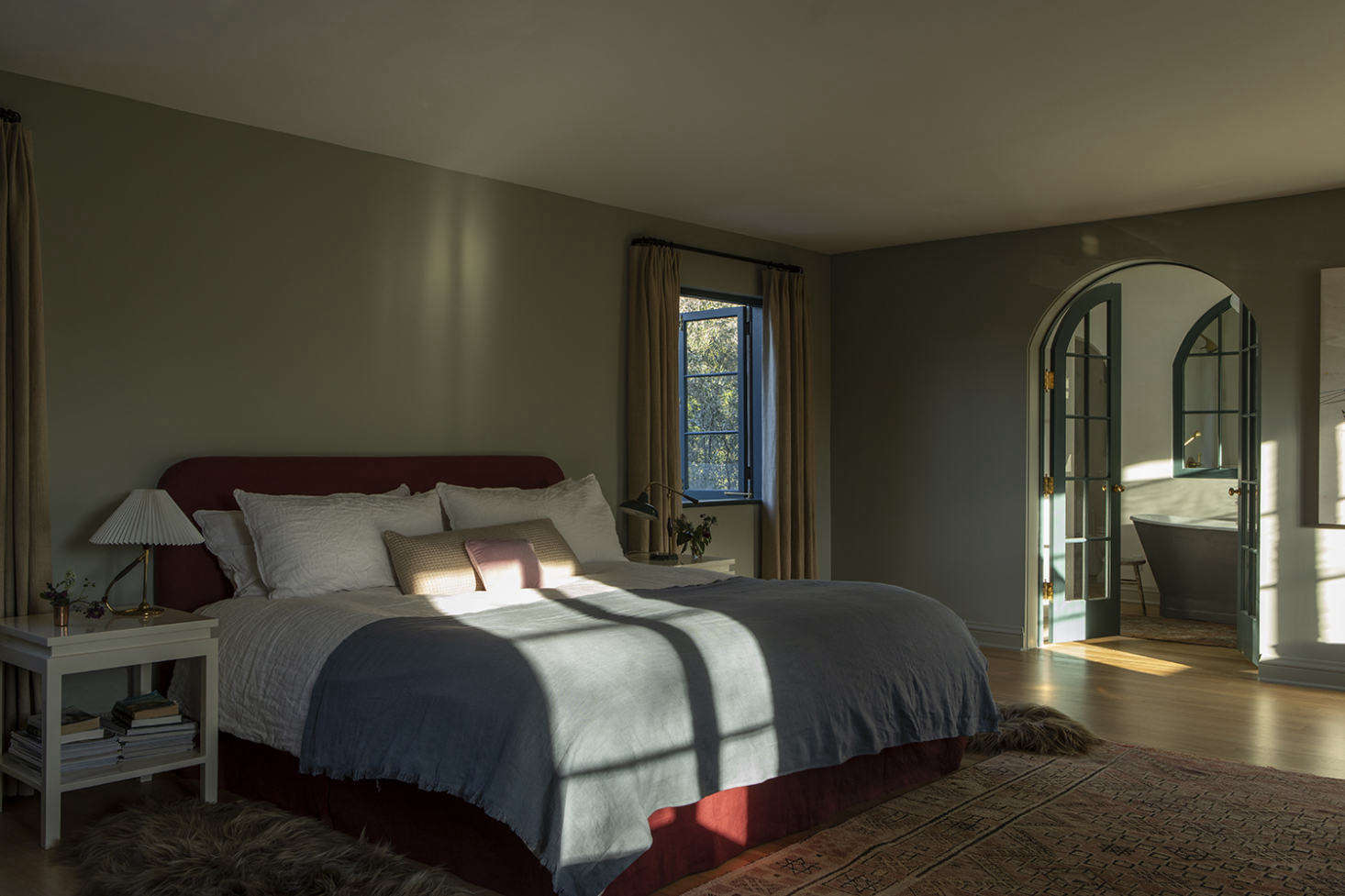 The master bedroom is cloaked in rich jewel tones and sunlight.