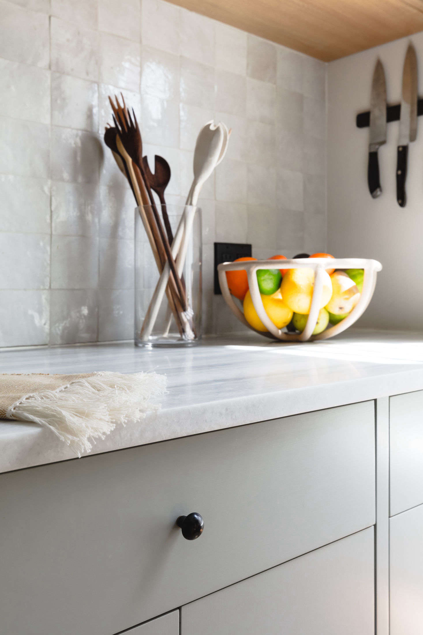 The backsplash is tiled with with Weathered White Zellige from Clé that lends the requested human touch: 