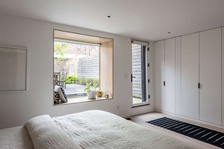 The master bedroom, relocated to the back of the duplex so that it has access to the yard, now has a window seat, lined in white oak, and ample built-in storage.