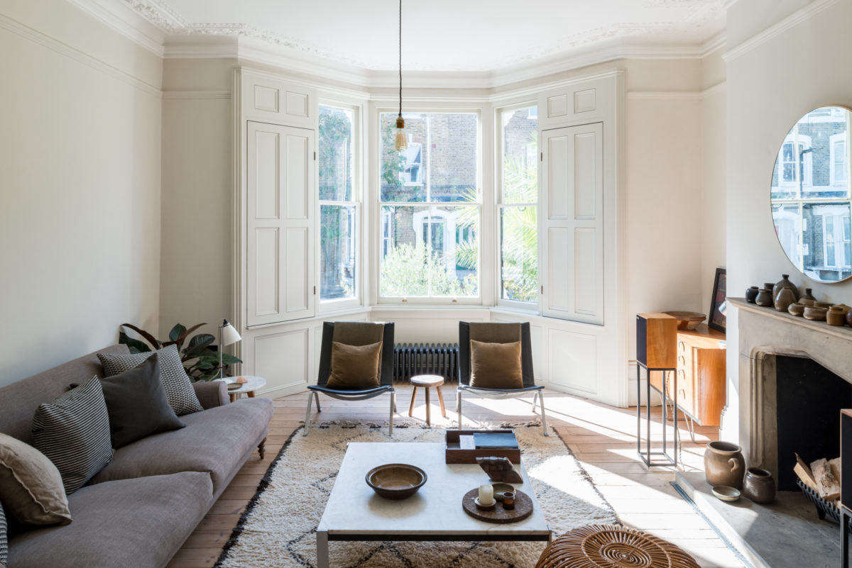 A Matthew Hilton sofa and a pair of mid-century Poul Kjærholm lounge chairs provide comfortable seating in the light-filled living room.