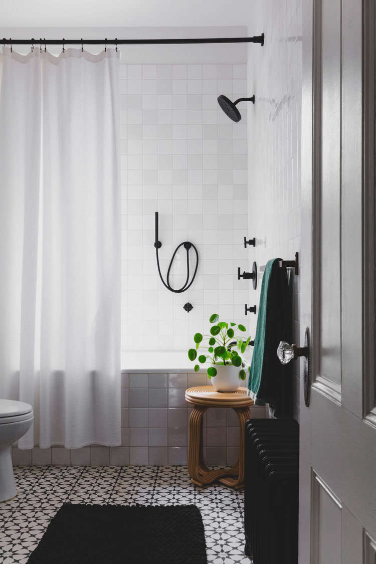 Like the entry, the bathroom has a black-and-white floor of Agadir Cement Tile: &#8