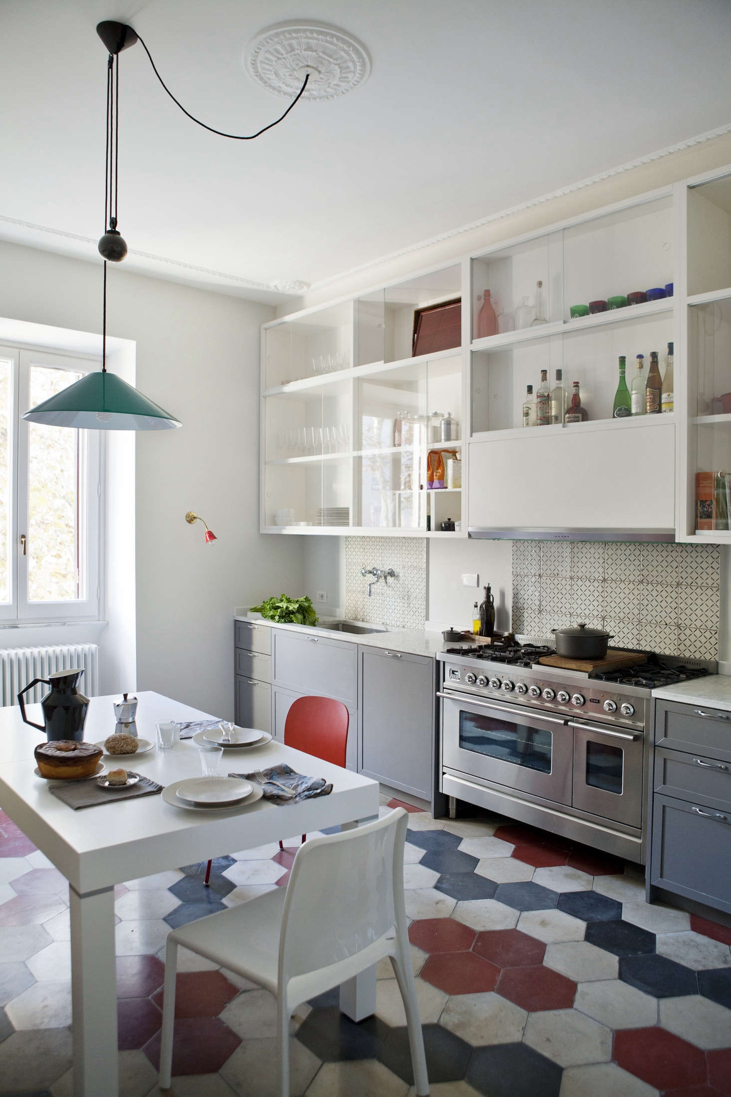 In the kitchen, a reclaimed cement-tile floor sets the stage for a motif of dusty reds and blues that appears throughout the house. 
